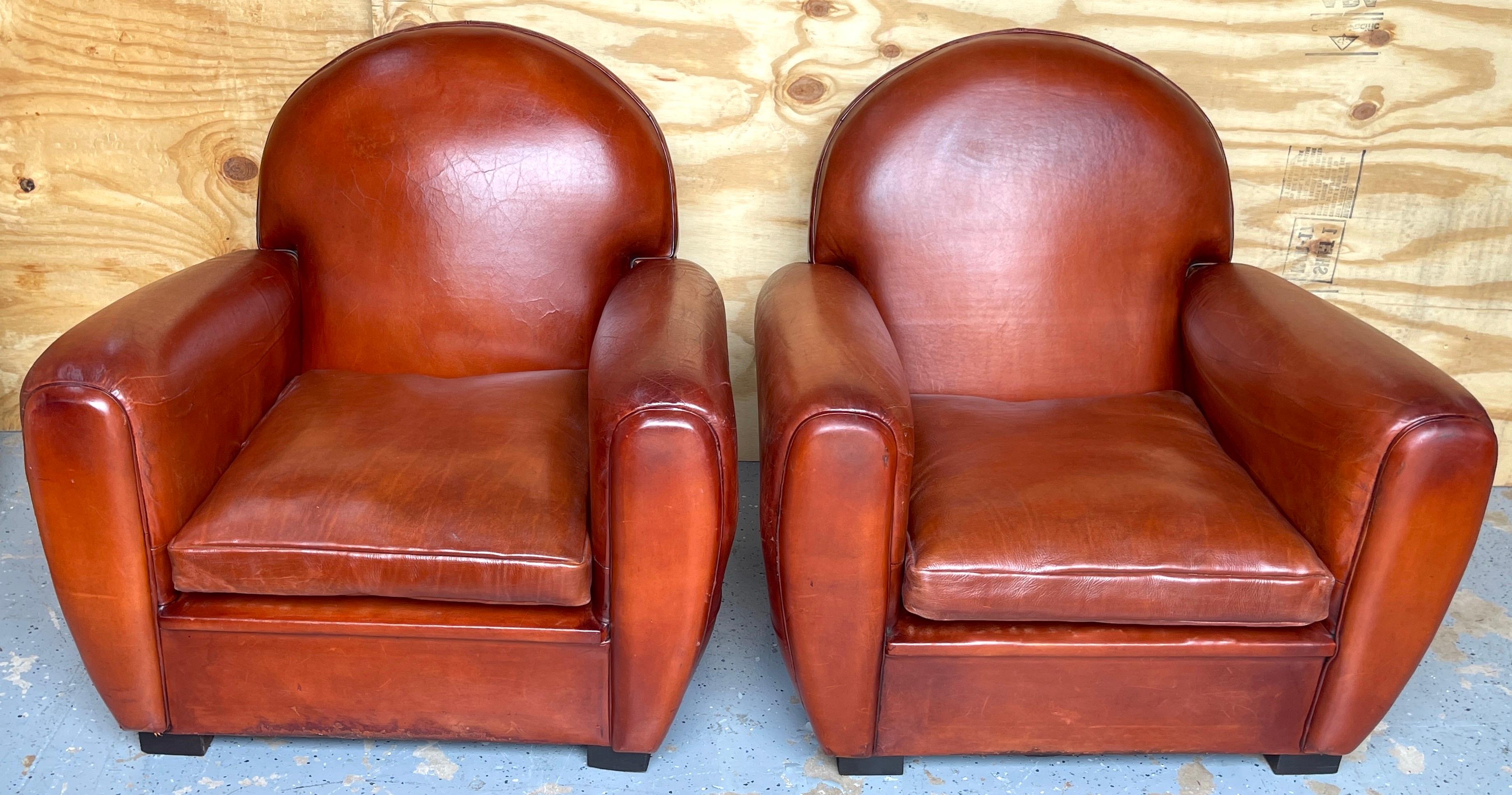 Pair of French Art Deco saddle leather chairs
France, 20th century
Each sumptuous club chair upholstered thick saddle colored leather, with random signs of use and patina, structurally sound. Raised on four ebonized wood square block feet. Ready to