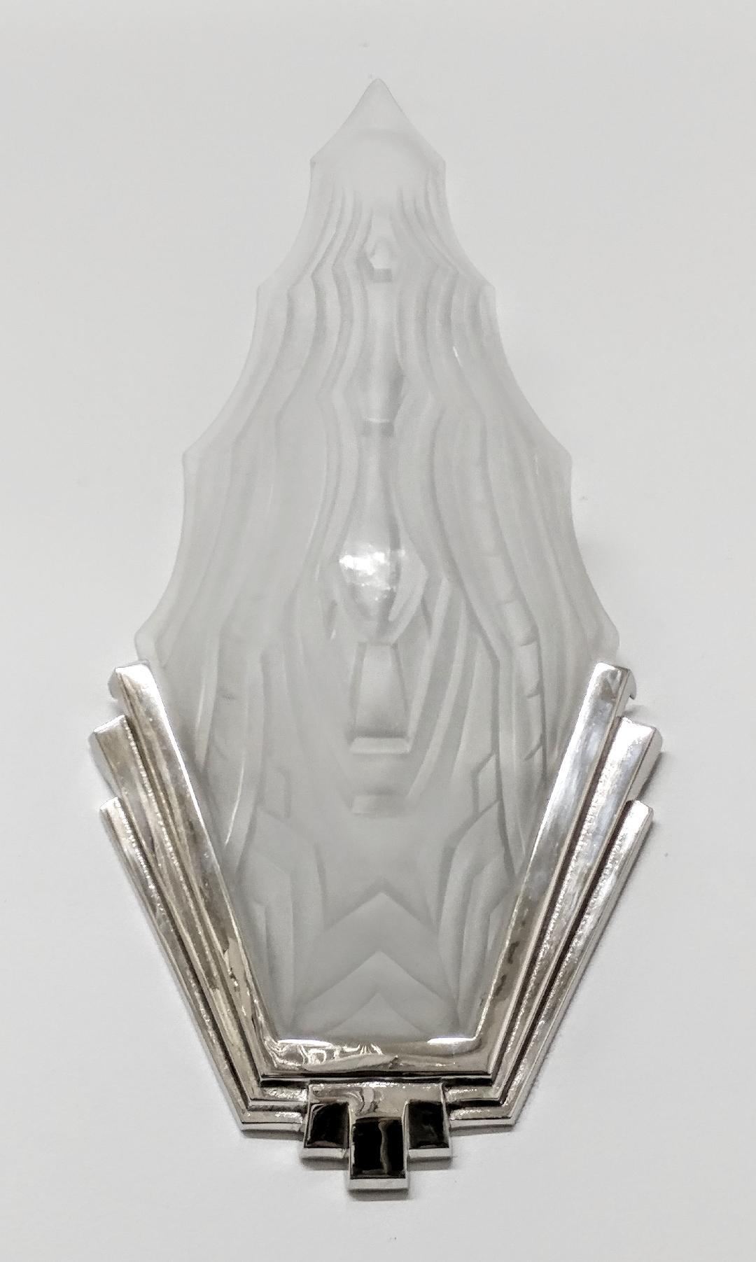 A stunning pair of French Art Deco wall sconces by the French artist “ Sabino “ in clear and frosted molded glass shades with geometric motifs. Held by polished nickel bronze geometric design frames. Replated in nickel and rewired to U.S. standards