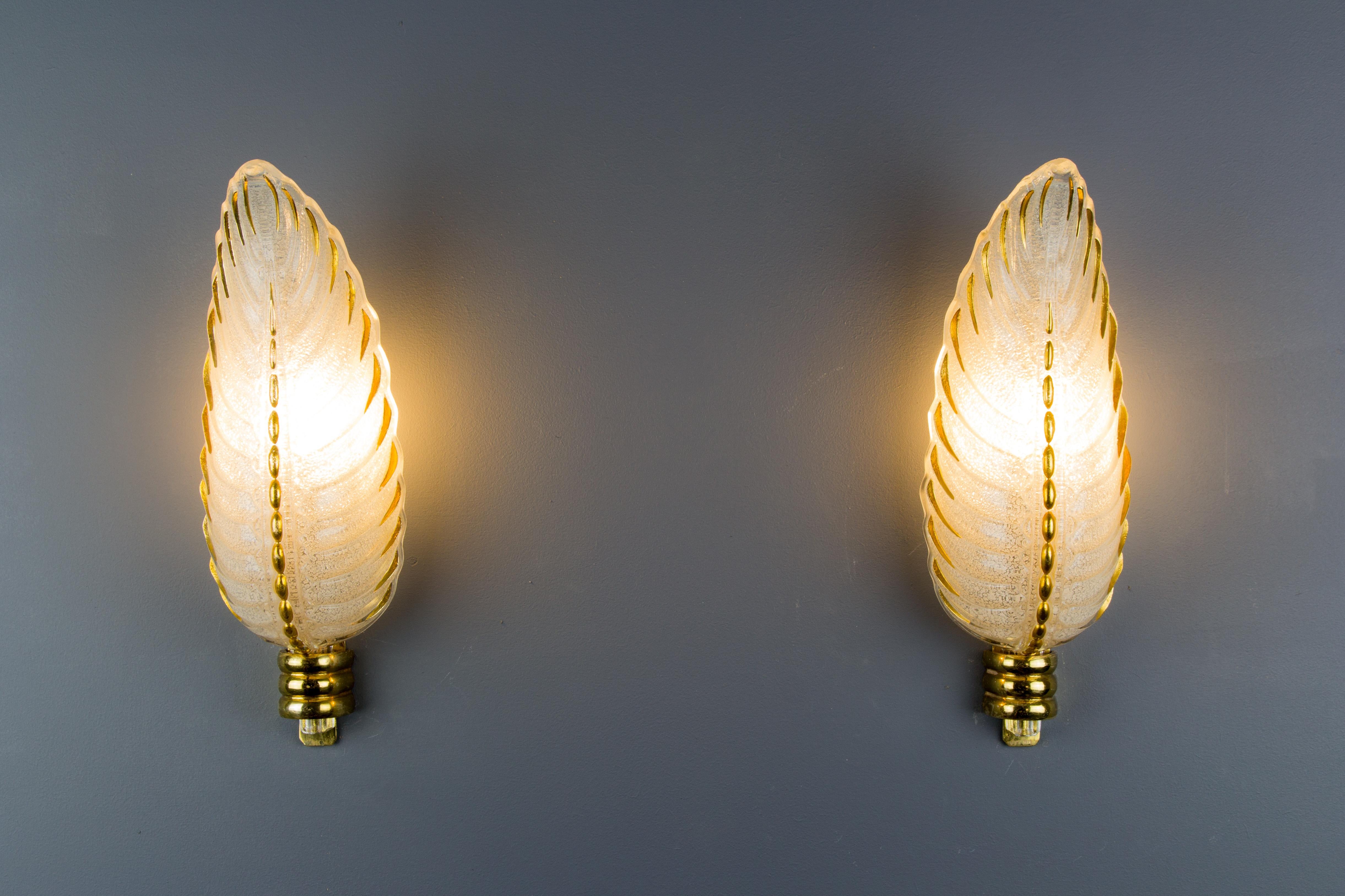 A beautiful pair of French Art Deco leaf design wall sconces by Ezan and Petitot from the late 1930s. Solid bronze mounts, marked by Petitot, hold enameled molded-pressed glass shades with a frosted structured surface high-lighted with gold enamel