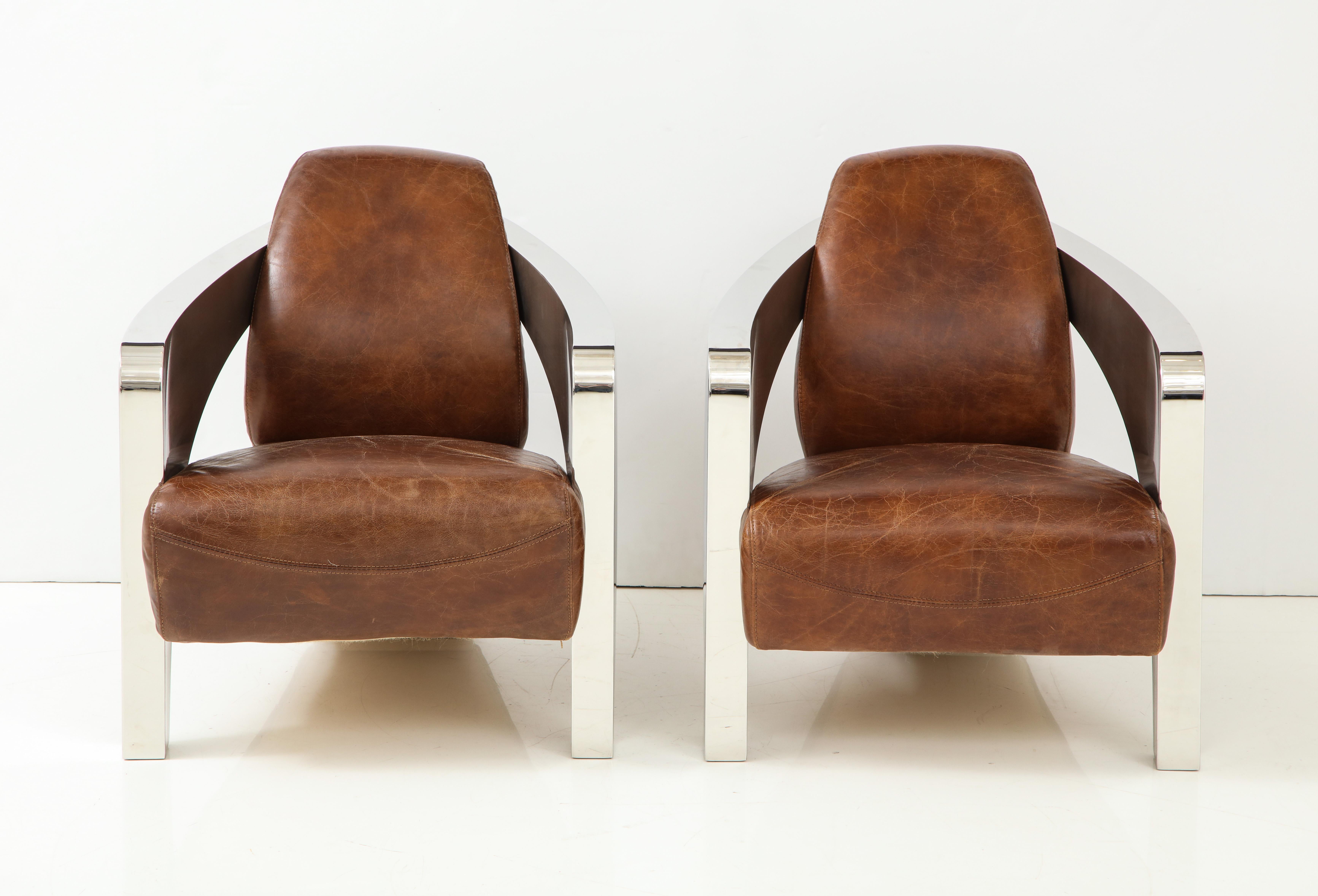 Pair of French Art Deco style aviator chairs; with sleek chrome curved support; with distressed brown leather seats and back. 
Size: 15” seat height x 28 1/4” back height x 25 1/2” wide x 32” deep.