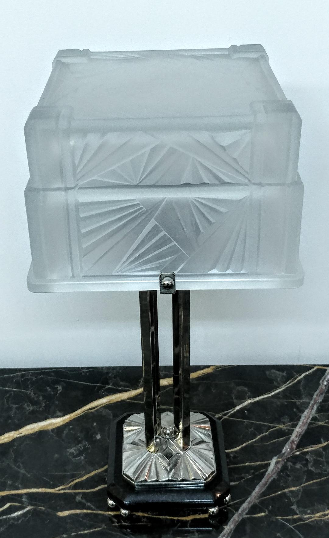 A stunning pair of French Art Deco table lamps were created by E.J.G. The square glass shade consists of a two-tiered design. Enhanced by typical French Art Deco geometric patterns motifs throughout. In clear frosted with polished details with a