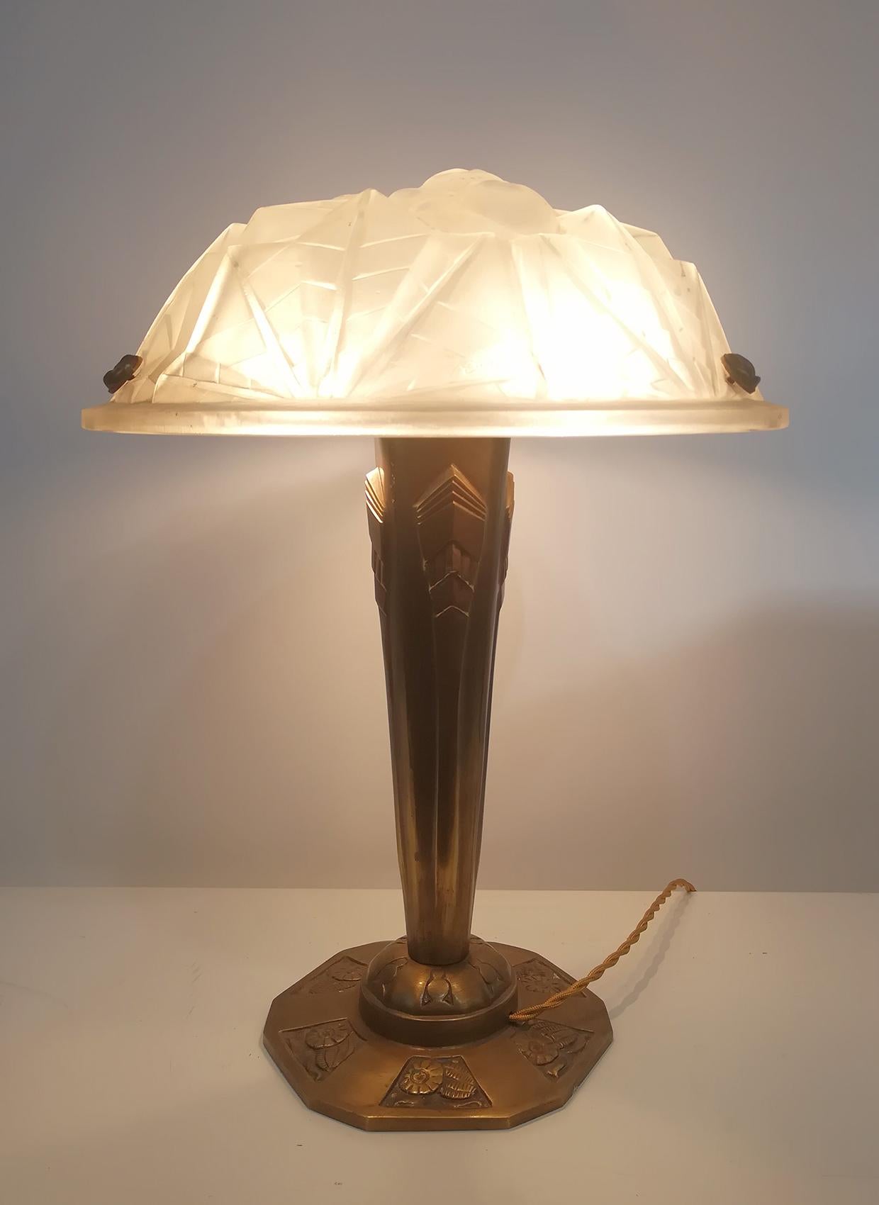 Charming pair of Art Deco table lamp, high quality molded glass panel (diameter 35 cm) with rare original floral motif design in relief included “Degué” signature on the glass, resting on bronze column with floral and geometric design