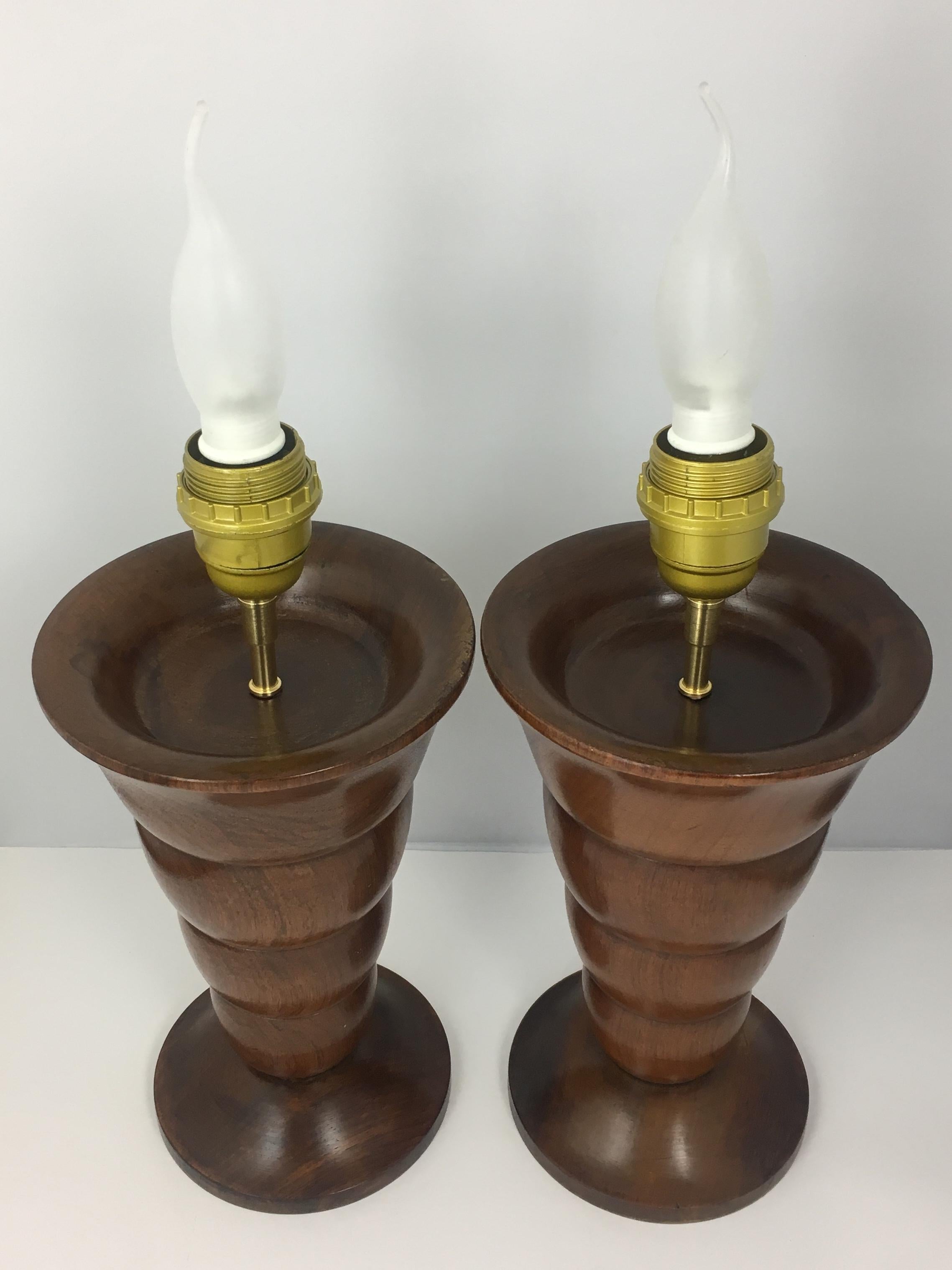 Pair of fine quality Art Deco solid exotic wood table lamps. 
Clean organic lines. 
These lamps are in perfect condition, bulb sockets are new. 

Currently wired for use in France, easily adjusts for use in select destination.

 