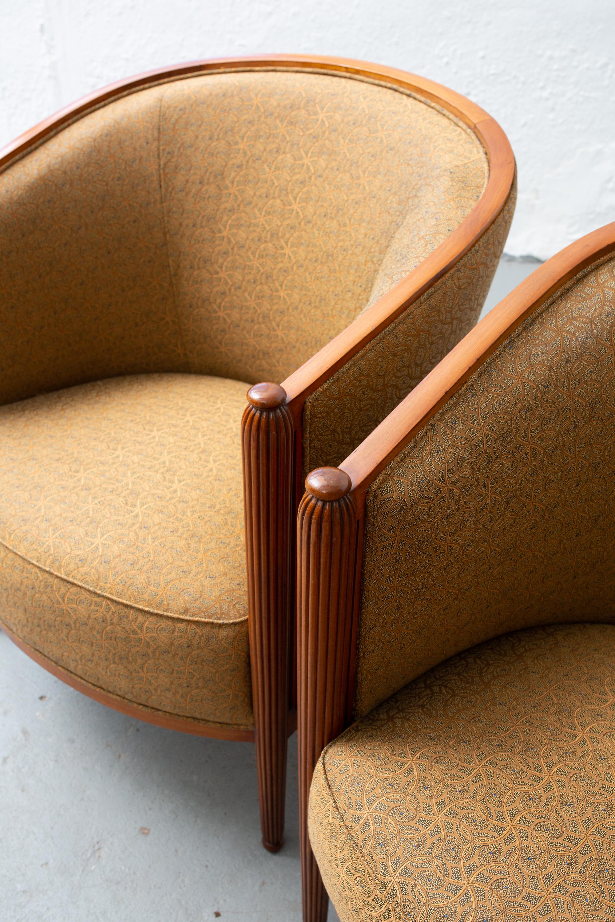 Pair of newly upholstered French Art Deco tub chairs with fabulous gold hued fabric with blue details. Fluted and tapered legs on front, closed arms.
Measures: Seat width 21