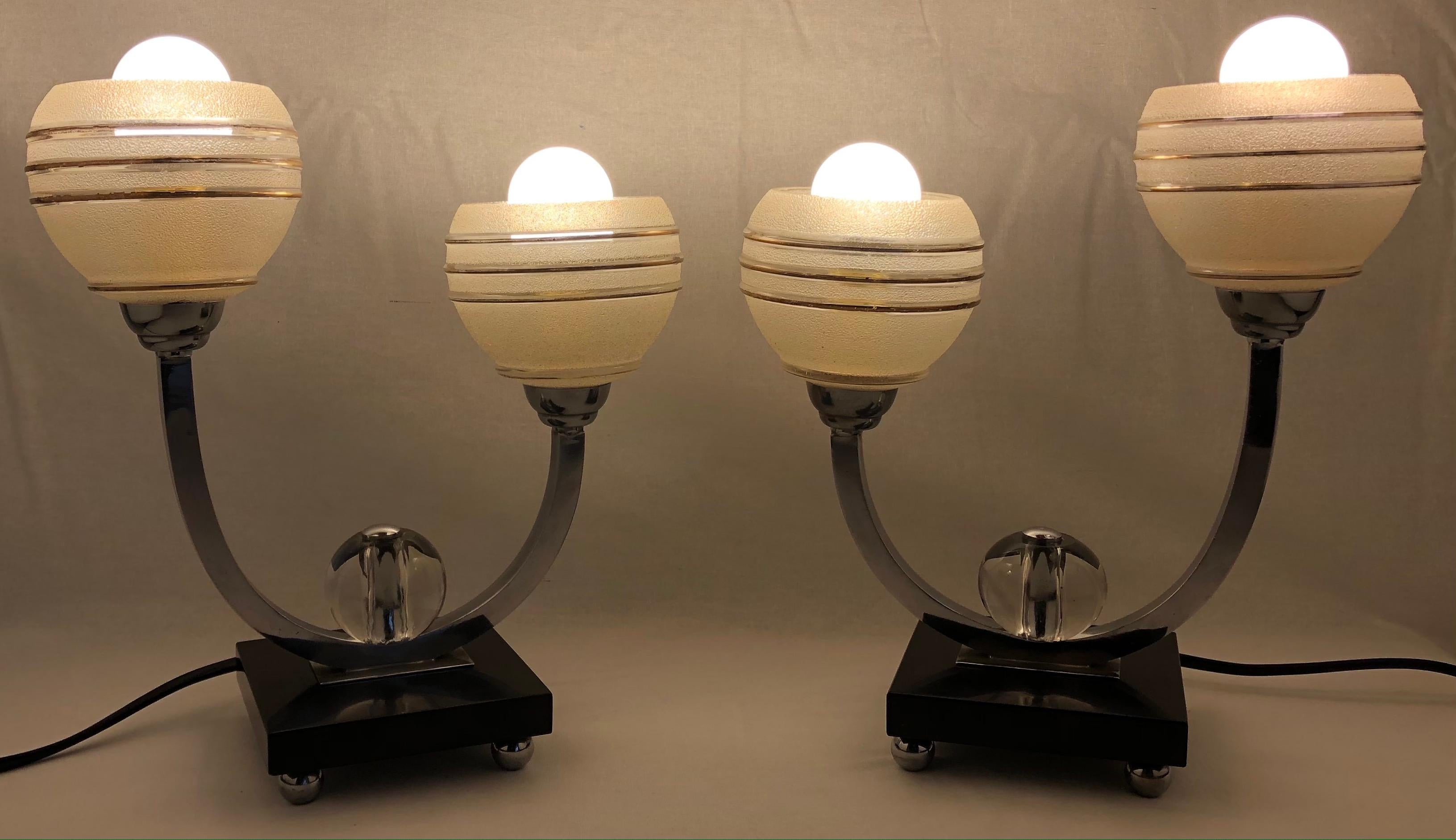 Very decorative pair of French art deco table lamps. These beautiful lamps are very good quality and are in perfect condition.

The striking frosted glass shades with gold trim are very pleasing to the eye, as are the black marble bases.
