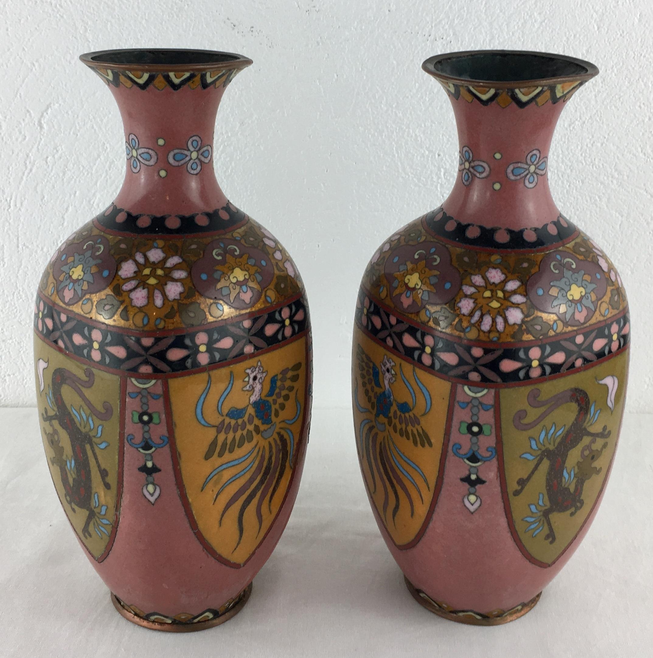 Vibrantly colored and intricately detailed pair of French Art Deco cloisonné vases with floral, geometric and animal patterns (resembles a phoenix).

Measures: 9 1/4