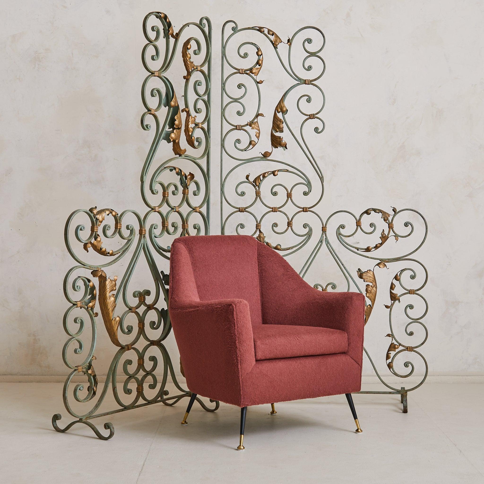 A pair of 1940s French Art Deco wrought iron screens, featuring scrolling motifs in an original verdigris-painted finish and accented with gilt tôle leaves. These elegant room dividers boast finely wrought ironwork and a sculptural presence,