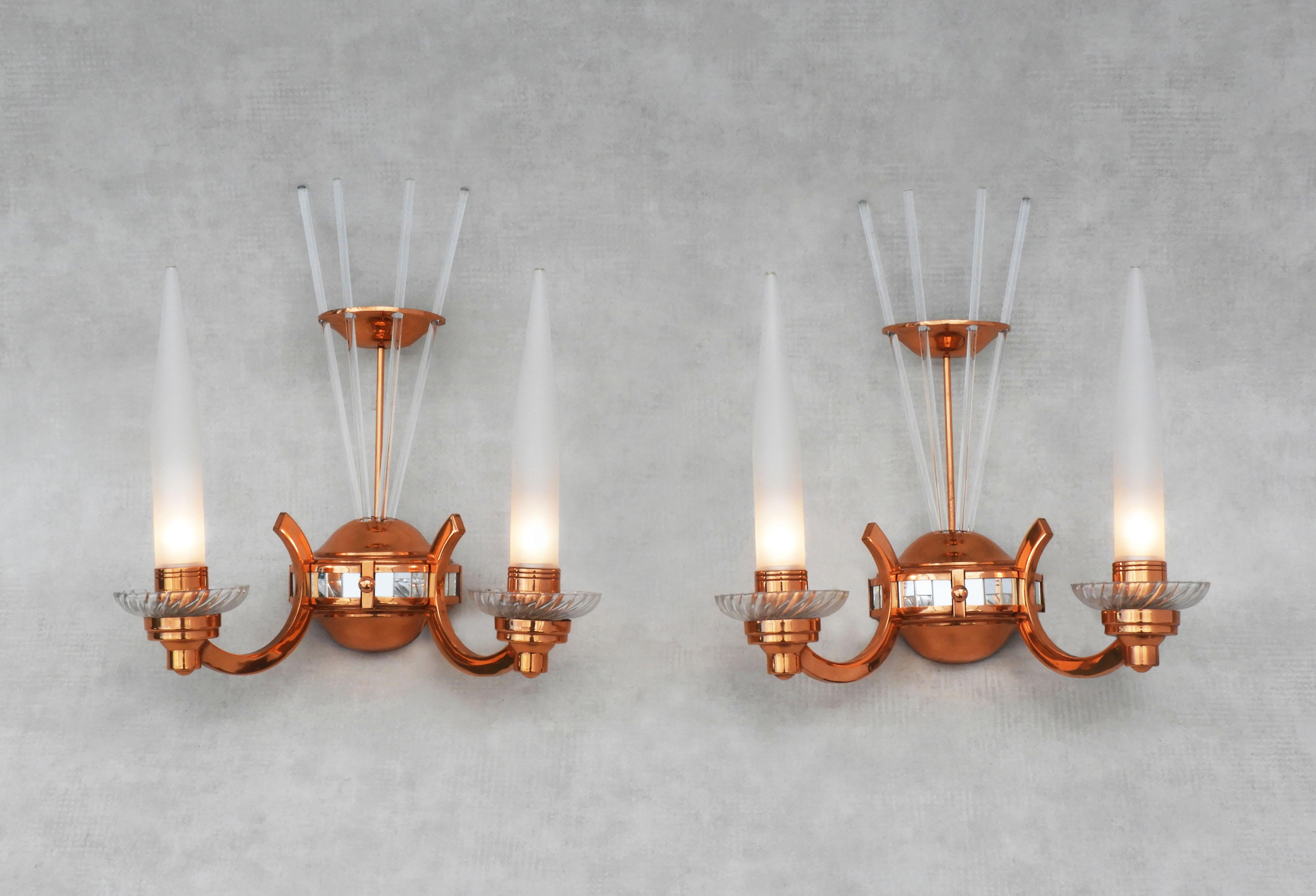 A stunning pair of French Art Deco wall light sconces attributed to Atelier Petitot.

Unusual copper and glass, demi orb shaped appliques decorated with a band of mirrored squares and four fine glass batons. Each light has two crystal bobeche and
