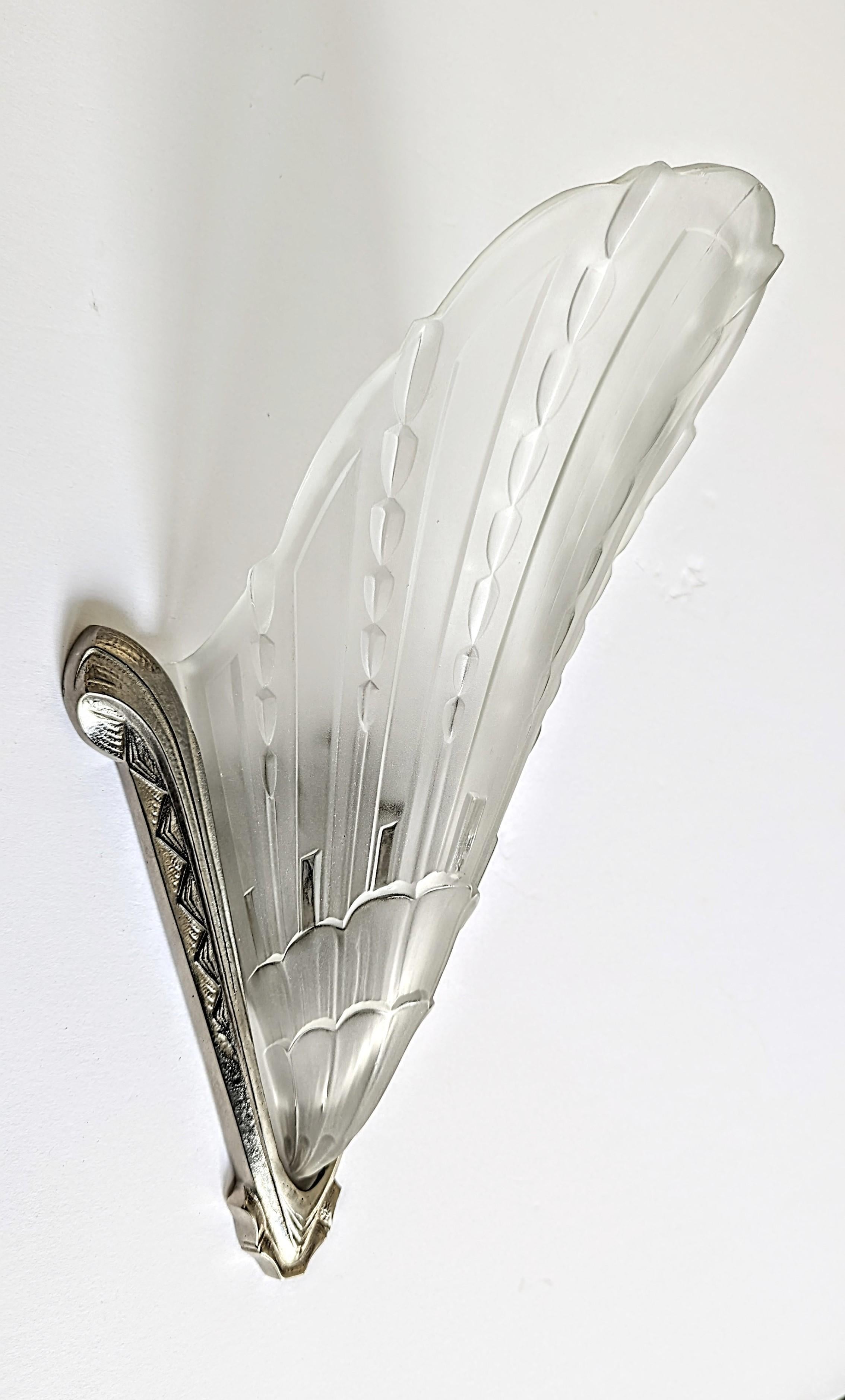 Paire d'appliques murales Art Déco de l'artiste français E J G. Abat-jours en verre moulé dépoli à motif géométrique Heldly maintenus par des cadres en bronze nickelé assortis et en très bon état. Les appliques ont été recâblées selon les normes