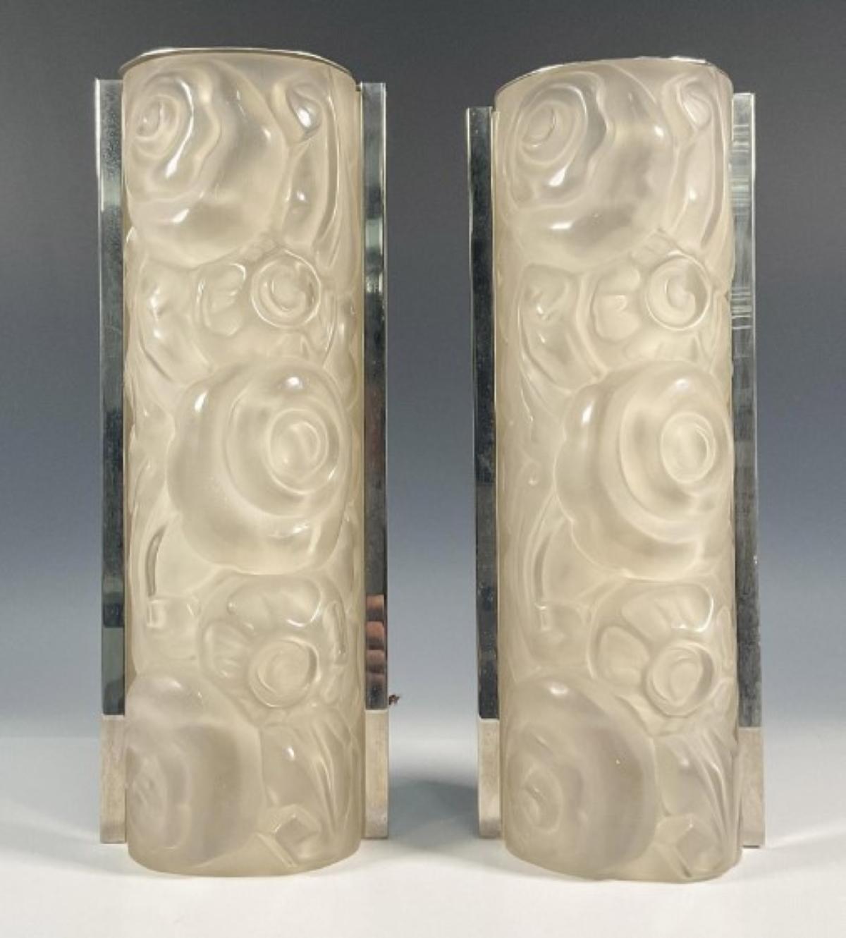 A pair of wall sconces by the French artist “Genet et Michon” in great condition. Clear frosted glass shades with flower motif details. Shades are held with nickel frames. These sconces have the added benefit that they can be hung horizontally or
