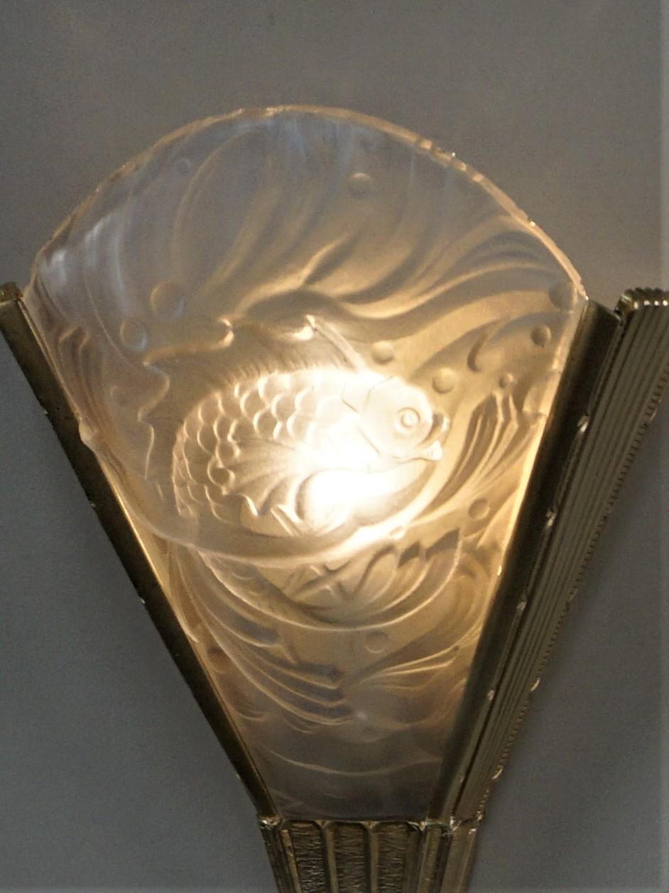 Beautiful pair of clear frost glass with fish motif and bronze frame wall sconces.