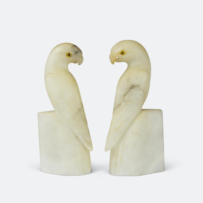 A pair of French Alabaster Parakeet bookends.

An elegant pair of 1930s French Art Deco parakeet bookends carved from naturally veined white alabaster with subtle grey hints and amber coloured glass eyes. Stylised animal forms were very popular in