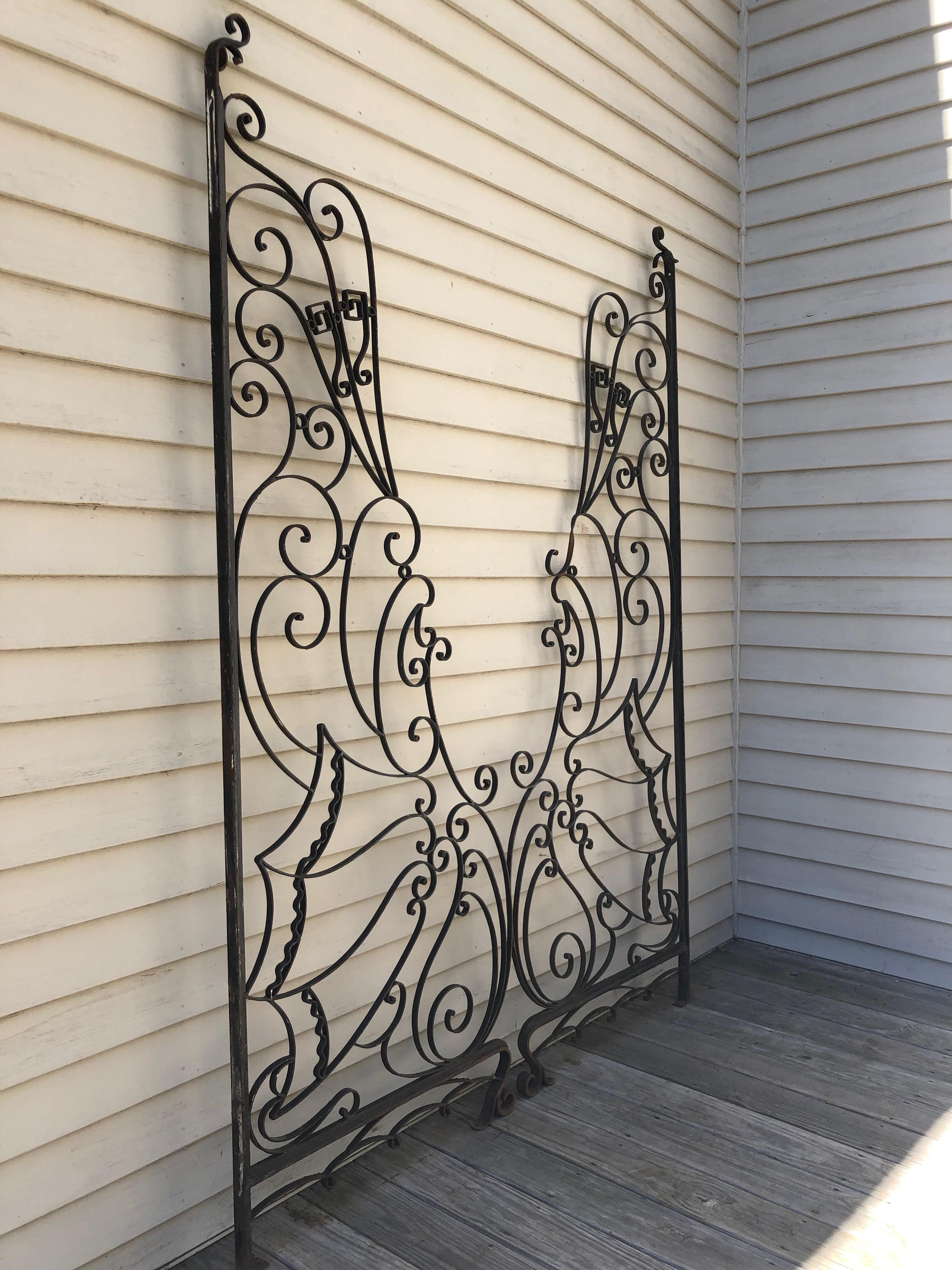 Originally used as balcony dividers and mounted front to back, envision these stunning Deco gates facing each other to provide the perfect frame for your garden or interior room. Handwrought of iron and with a delicate and intricate scrolling form,