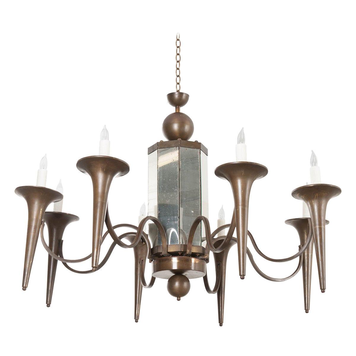 This fabulous and large pair of Art Modern bronze finished eight-light chandeliers, circa 1930s, are from France and feature a paneled and mirrored standard, composed of old and new mirror plates, suspending eight scroll-arms terminating with