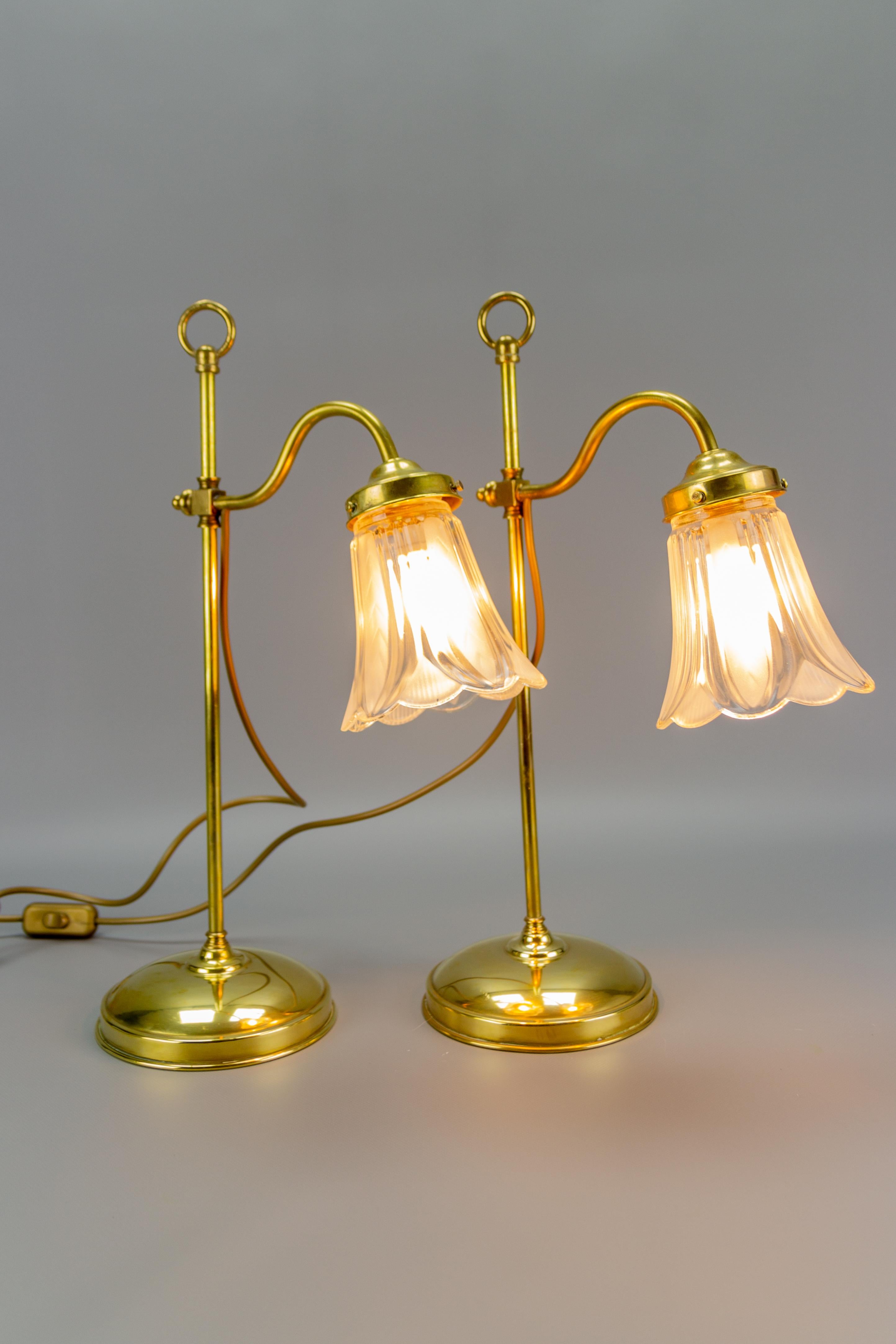 Ensemble de deux élégantes lampes de table de style Art Nouveau. Fabriqué en laiton avec un abat-jour en verre en forme de fleur. Hauteur réglable, chacune avec une douille pour une ampoule de taille E27 (E26). France, années 1930. Pour les