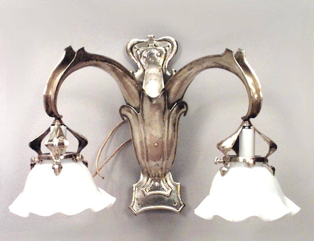 Pair of French Art Nouveau brass wall sconces with two arms, fleur de lis front panels and white scalloped glass shades. (PRICED AS Pair)
