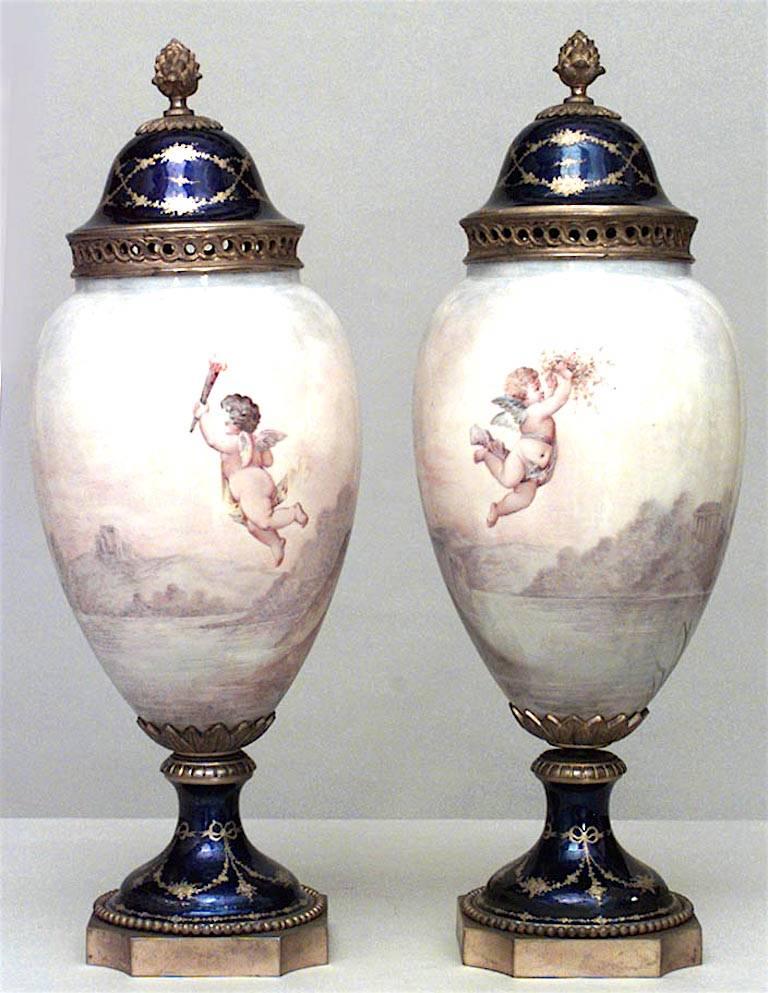 Pair of French Art Nouveau enamel and Sevres porcelain vases with cover having a scene of a winged woman with a bronze finial and base (as is-rePairs to base) (PRICED AS Pair)
