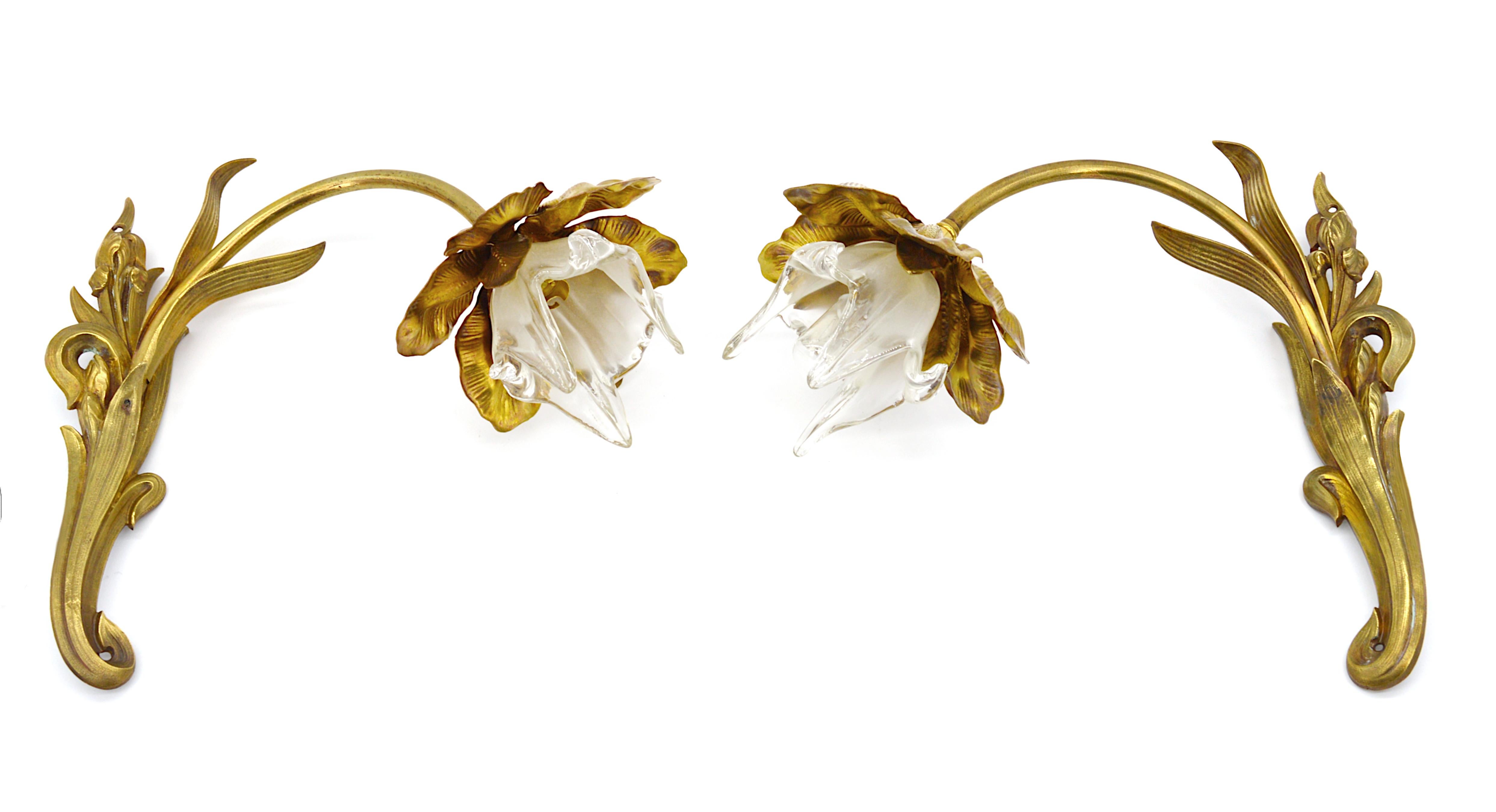 French Art Nouveau pair of wall sconces, France, circa 1900. Bonze and glass. Each wall light represents an iris. Lampshades are made of glass worked with pliers. The glass is partially frosted. Measures: Height 11.2