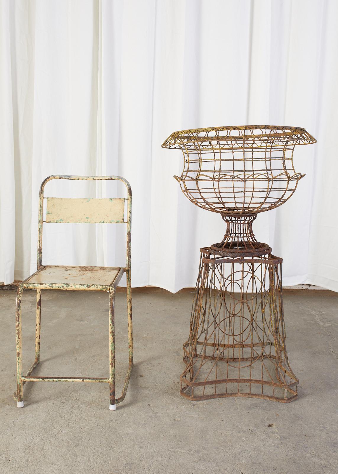Fantastic pair of French Art Nouveau jardinières on pedestal stands. Crafted from thick iron wire into graceful, whimsical forms with each standing 40 inches high. Decorated with beautiful curves and shapes the stands have a naturally inspired form