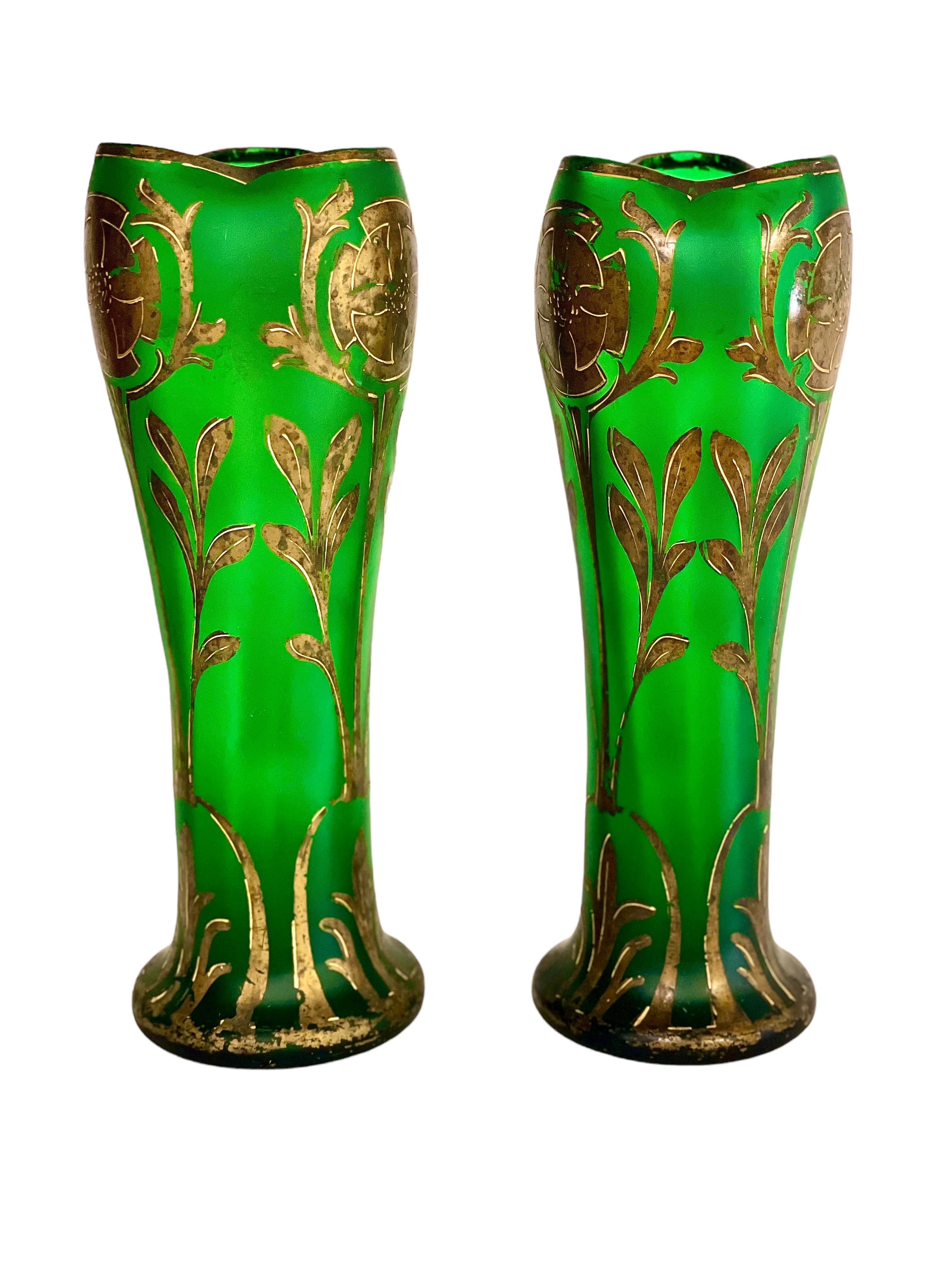 An unusual pair of Art Nouveau period hand-painted green glass vases, with undulating gilded rim and flared base. These elegant, floral-decorated vases date from around 1880-1900, and come into their own when bathed in sunlight in a bright room.