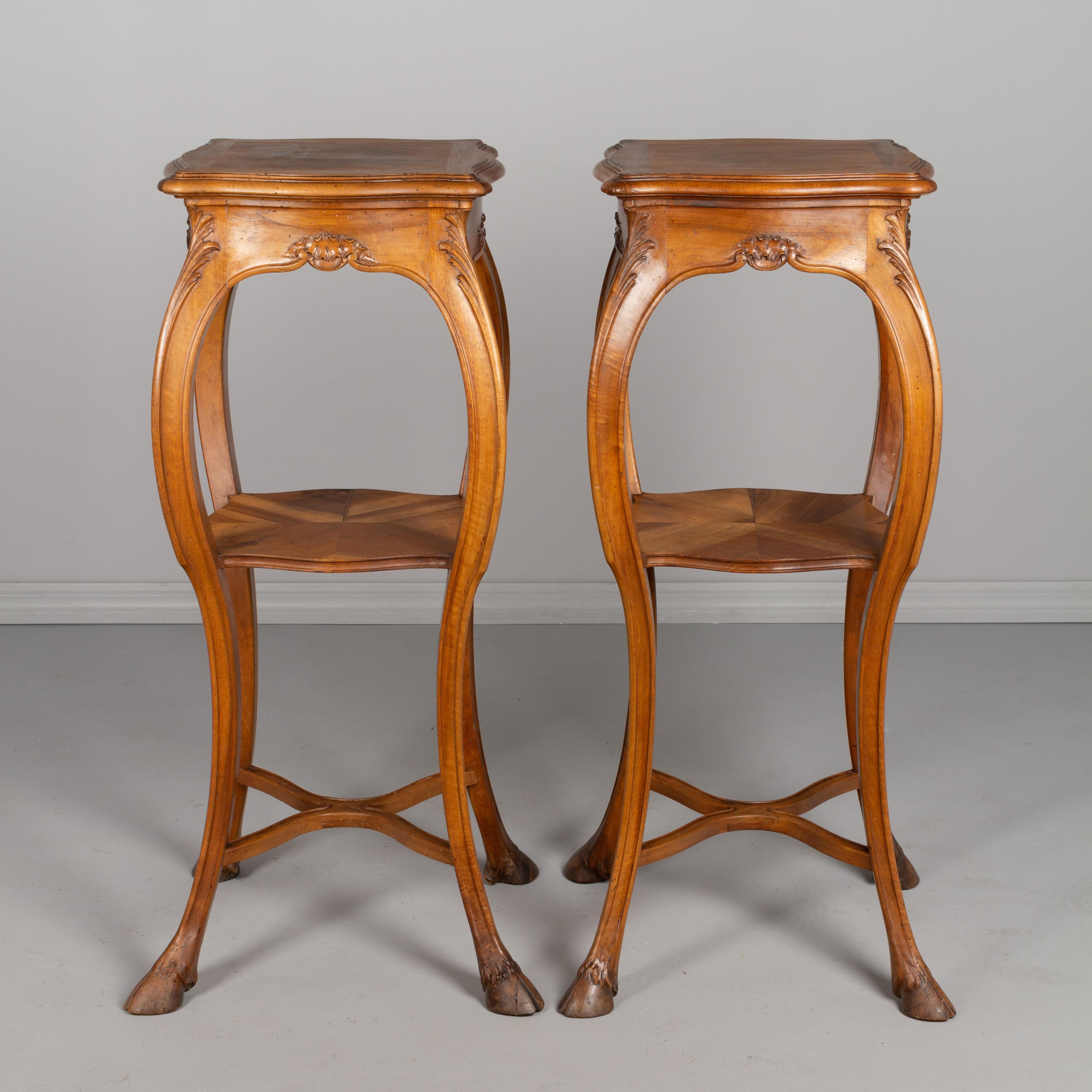 A pair of French Art Nouveau Louis XV style sellettes or tall pedestals mounted on very high feet. Made of walnut, with curved legs ending in carved deer hoofs. A dramatic matched pair for the display of plants or sculptures. Measures: Height 44