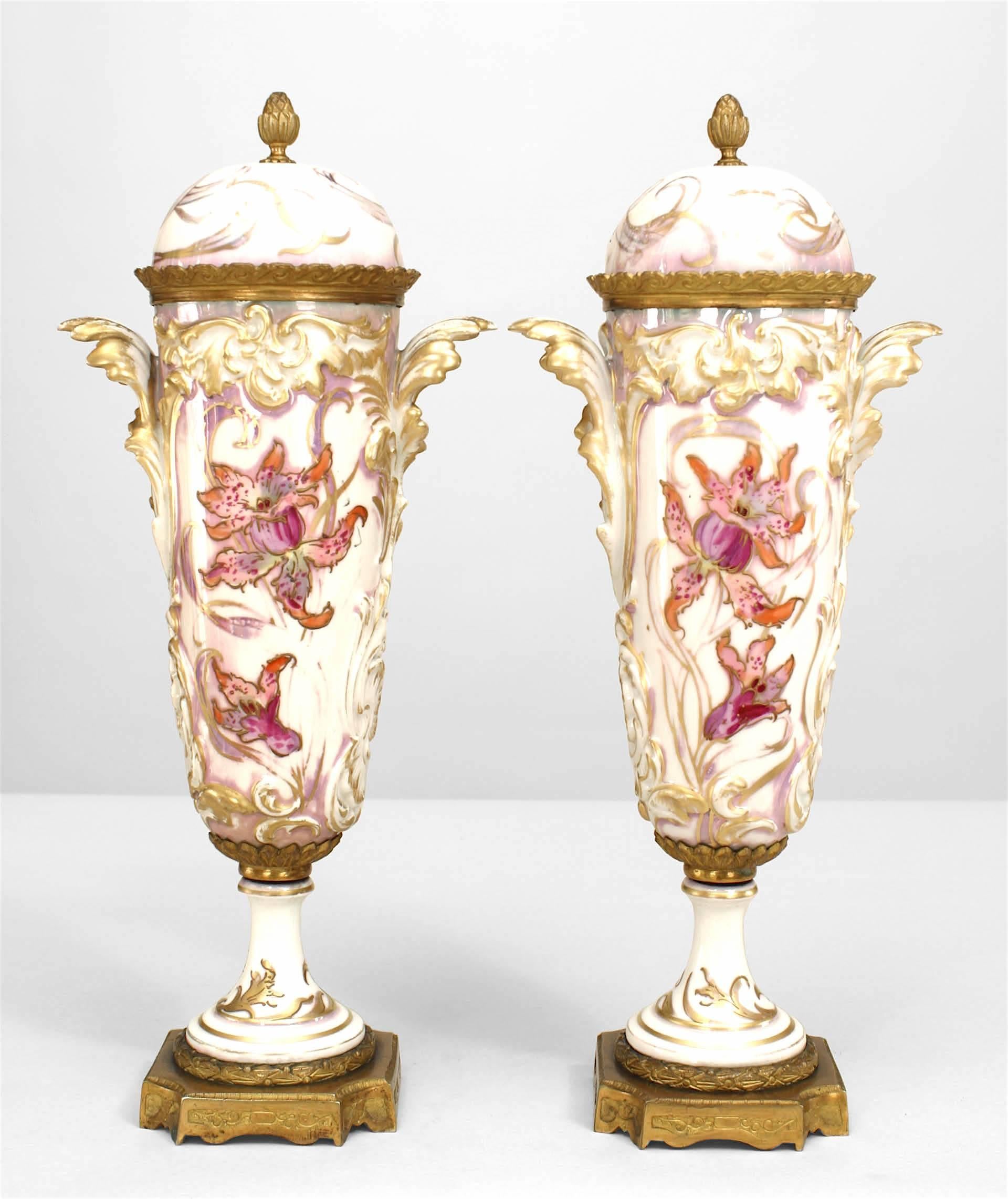 Pair of French Art Nouveau Sèvres porcelain vases with pink and gilt trim and female figure with cover and leaf handles.
     