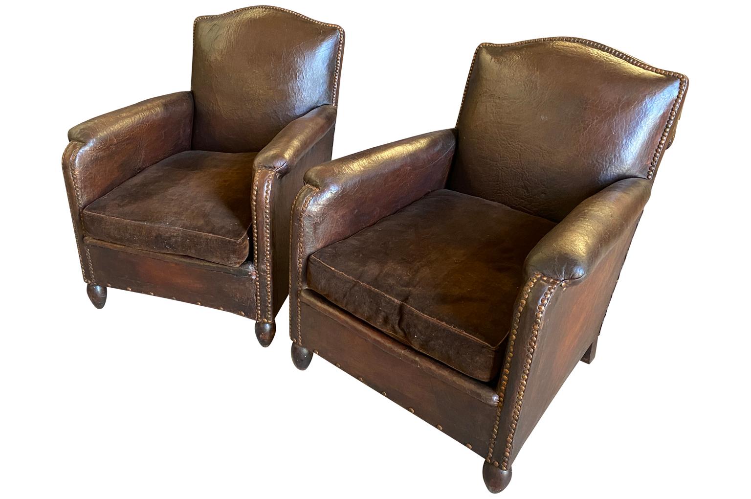 A sensational pair of classical French Arte Deco Club Chairs in beautiful leather with velvet cushions and handsome nailhead detailing.