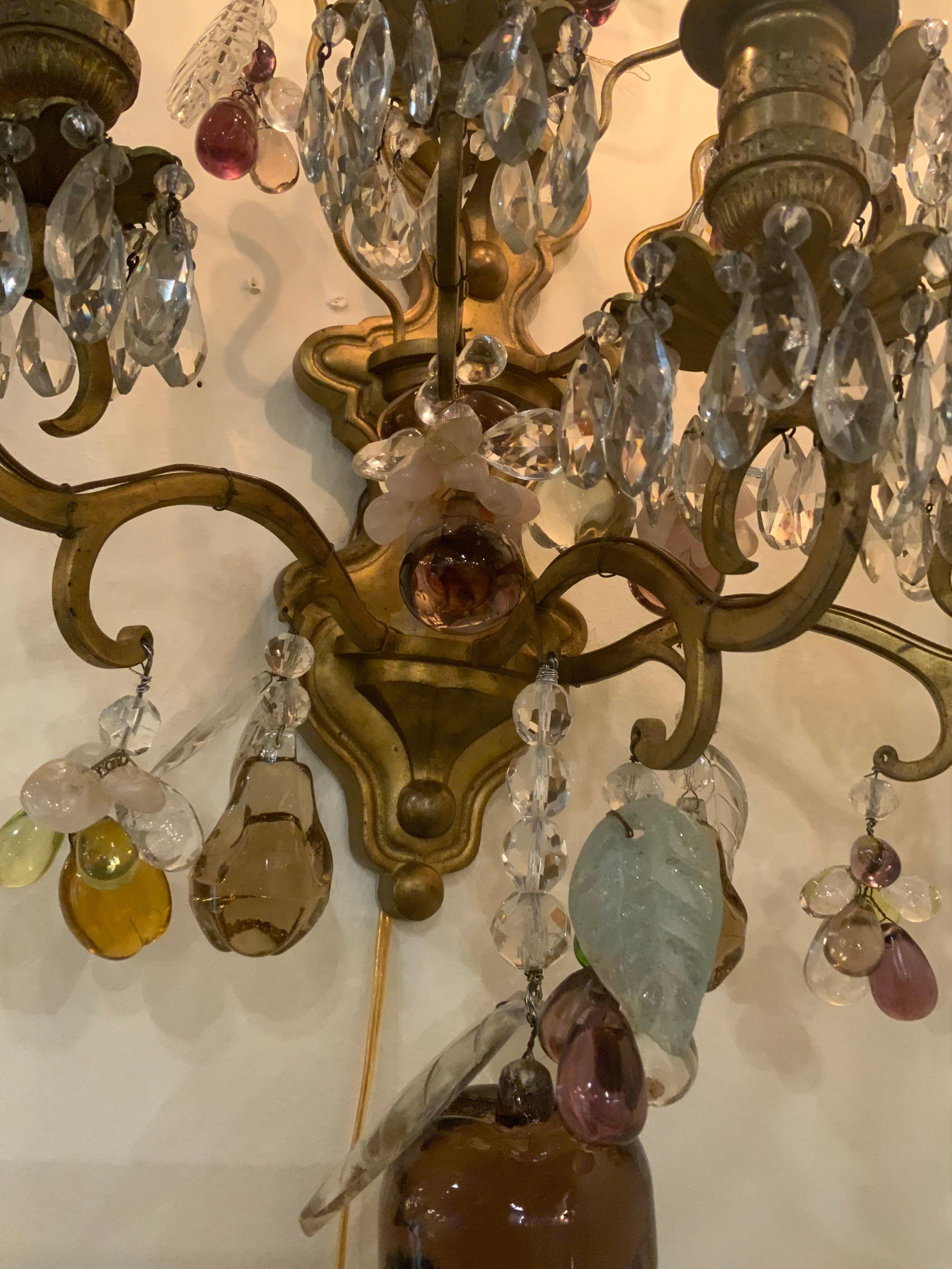 Exceptional quality of the bronze and gilding of the
Sconces is very fine. The shape is also unique
With a multitude of colored crystal and shapes 
Like various fruits. The colors of the crystal are purple,
Amber and clear.