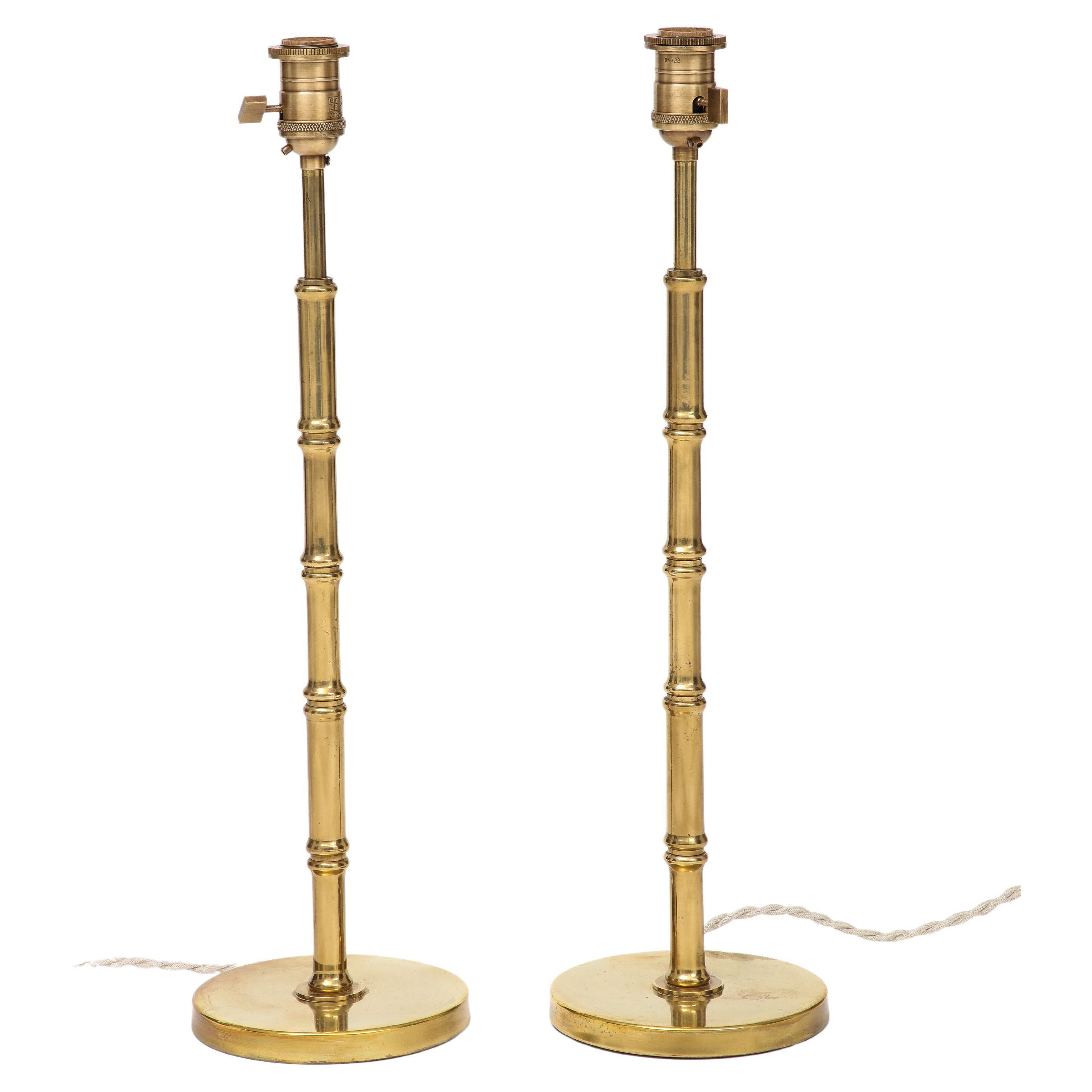 A pair of midcentury French brass table lamps, in the style of Baguès. Circa 1960s. Rewired for use in the US. Switch on socket. Weighted base. Minor dent on the base of one of the lamps.