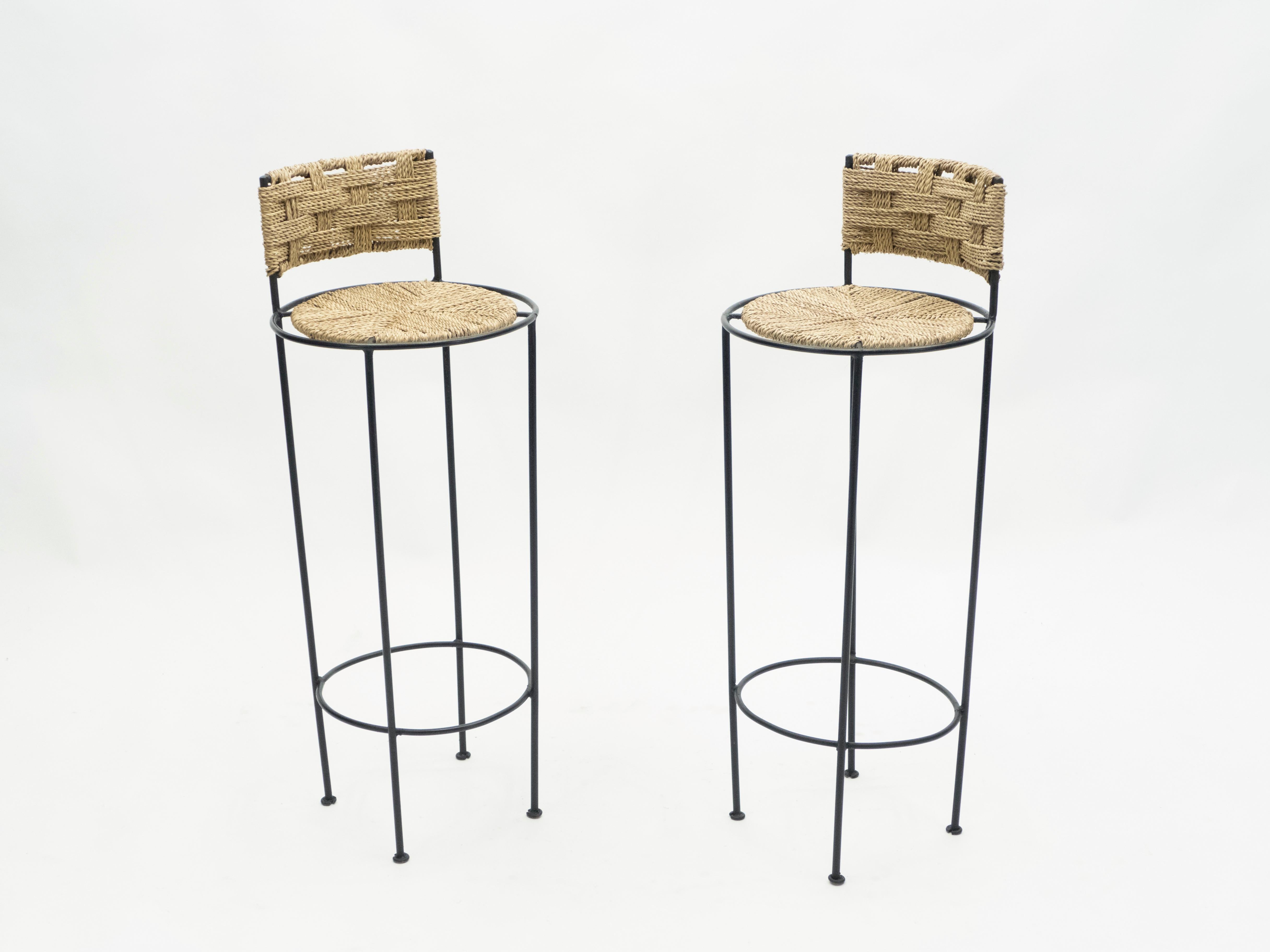 Beautiful patina is evident along the abaca rope seating and backrest of this pair of bar stools by Adrien Audoux et Frida Minet, giving away their vintage status. This natural style is typical of the French design of Audoux-Minet. Timeless