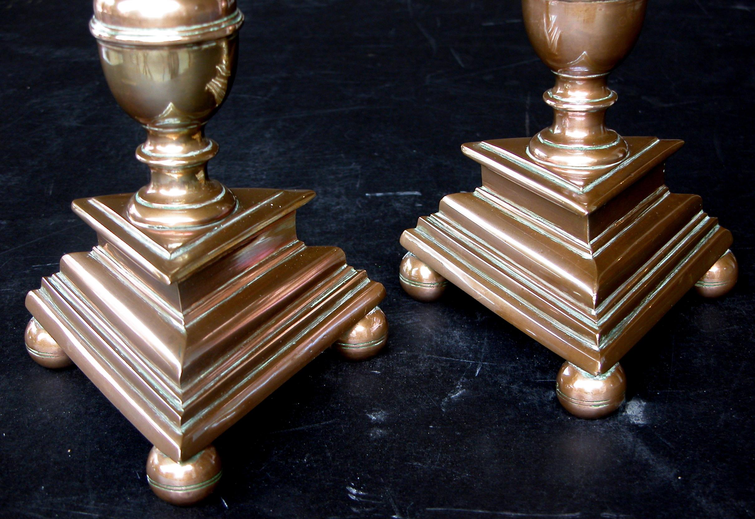 Each robust stick with deep cup above a double-baluster support; raised on a tripartite base with spheroid feet; height 18