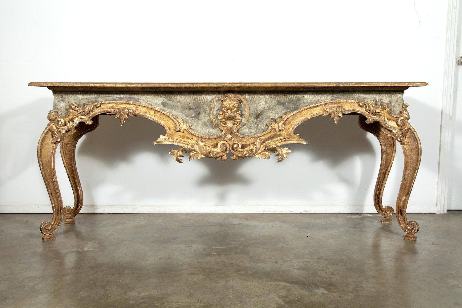 An exceptional French Baroque style console tables, handmade from 18th century painted and parcel gilt fragments, having rectangular scrubbed pine plank top. In typical Baroque manner, the ornate base features a central grotesque mask with