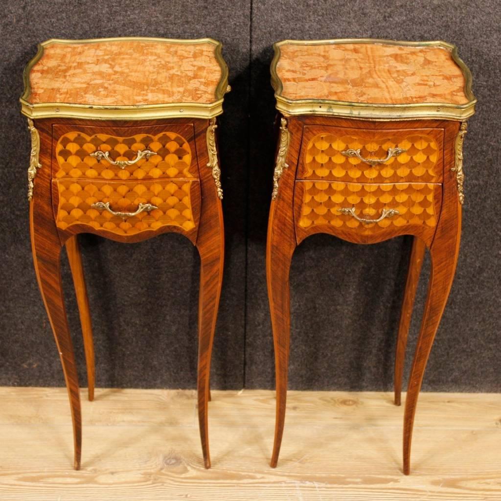 Pair of French bedside tables from the mid-20th century. Furniture of great elegance pleasantly inlaid in palisander, mahogany, maple and fruitwood. Bedside tables in Louis XV style, decorated with gilt bronzes and fitted with two frontal drawers