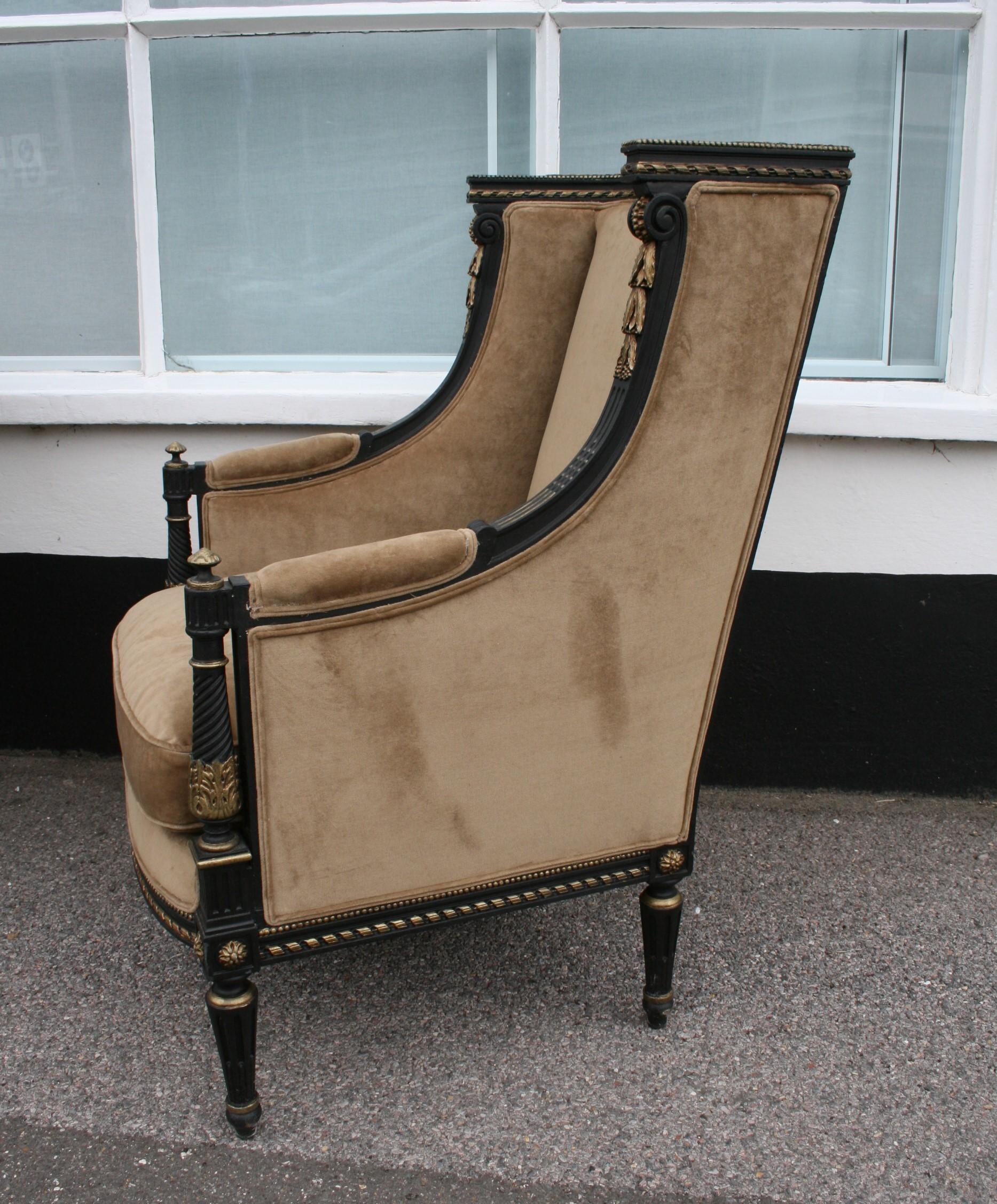 A very well carved pair of French armchairs in ebonized and gilt finish, newly recovered in an old gold velvet, complete with new feather cushions.