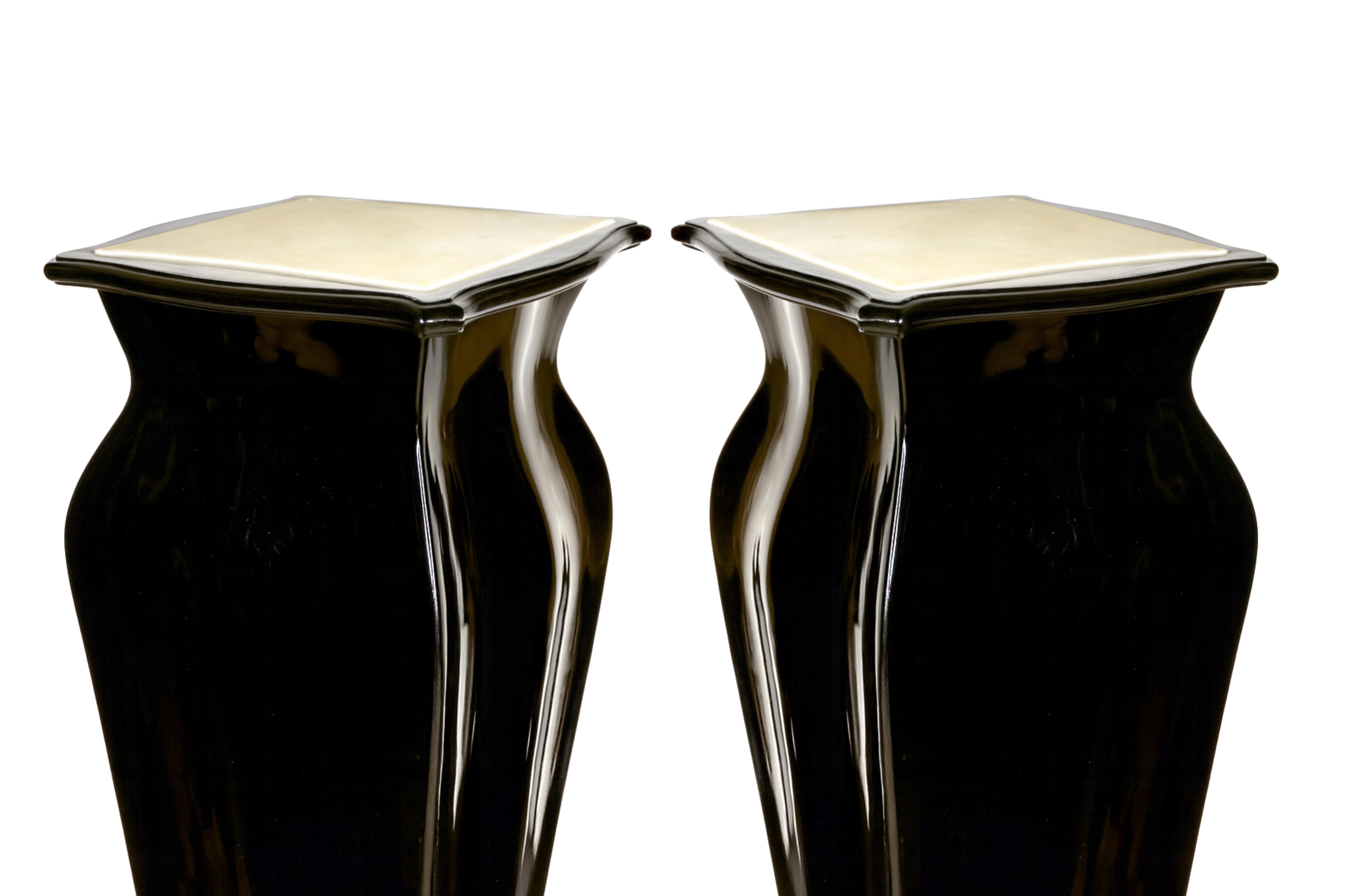 Una vivace coppia di piedistalli con piano in marmo, finitura nera lucida e piedini corti. 
La decorazione è espressiva ma raffinata, combinando lo stile Luigi XV con la raffinatezza Luigi XVI. 
Una coppia vibrante ed elegante, destinata a ravvivare