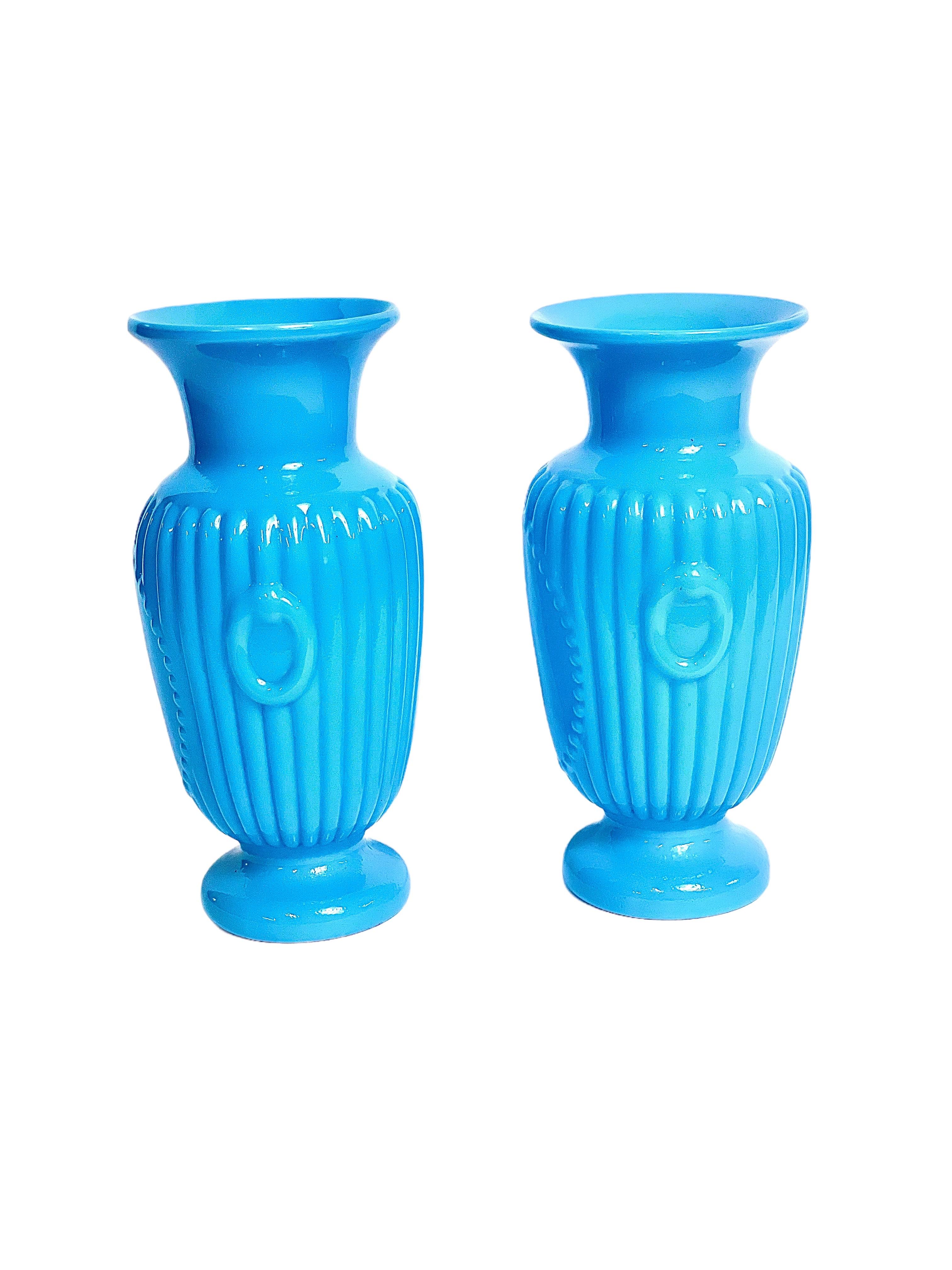 These striking ornate vases, crafted in vibrant turquoise blue opaline and believed to date back to approximately 1870 during the Napoléon III era, exude timeless elegance. Although unmarked, these vases beautifully embody the distinctive style and