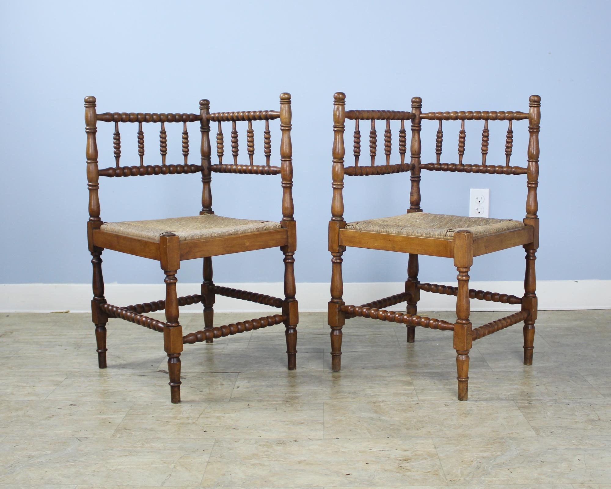 A charming pair of fruitwood corner chairs with original rush seats.