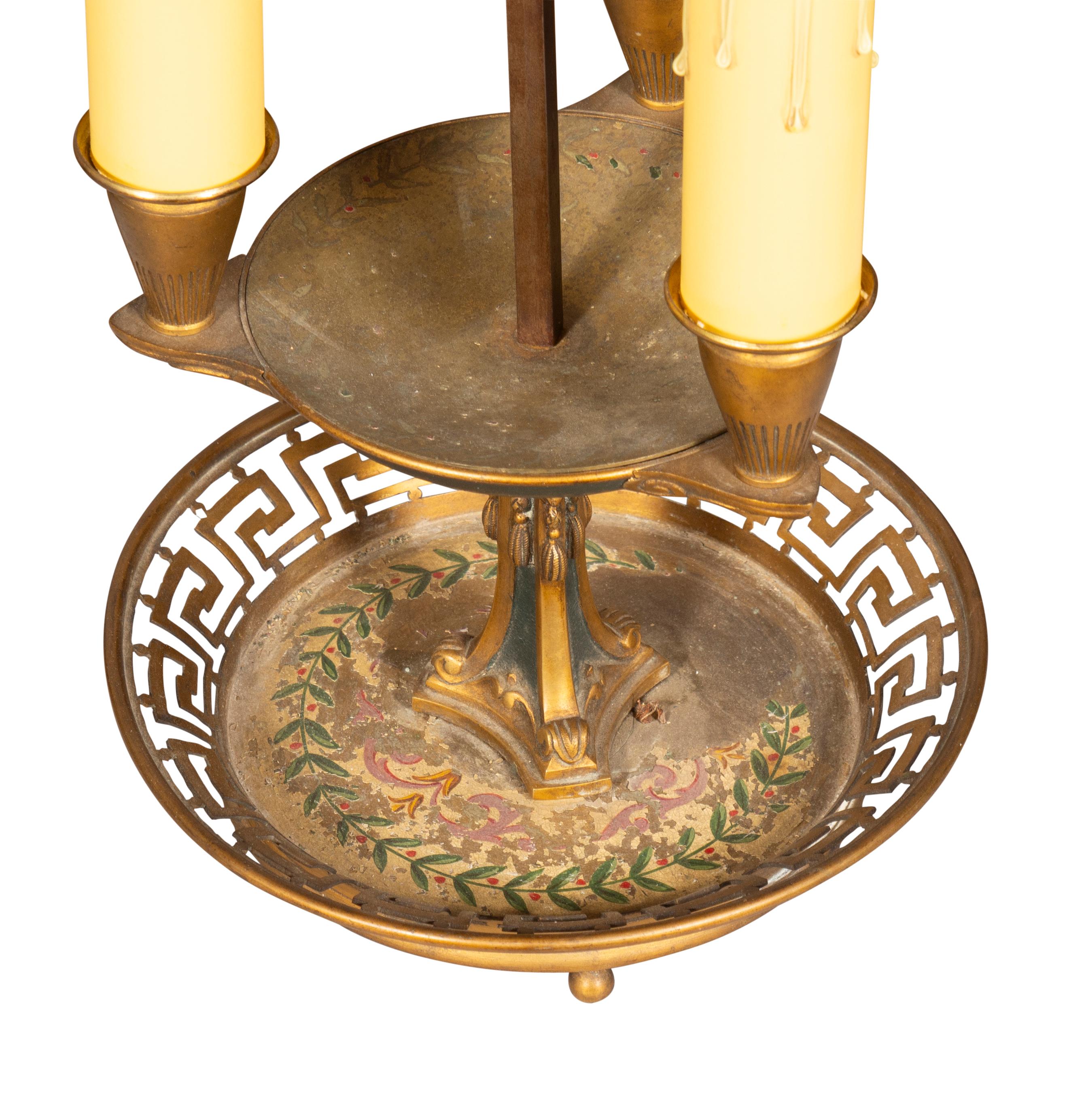 La paire est dotée d'un abat-jour réglable en métal peint et d'une base en bronze réticulée avec décoration intérieure peinte. Chacune d'entre elles est dotée de trois lumières.