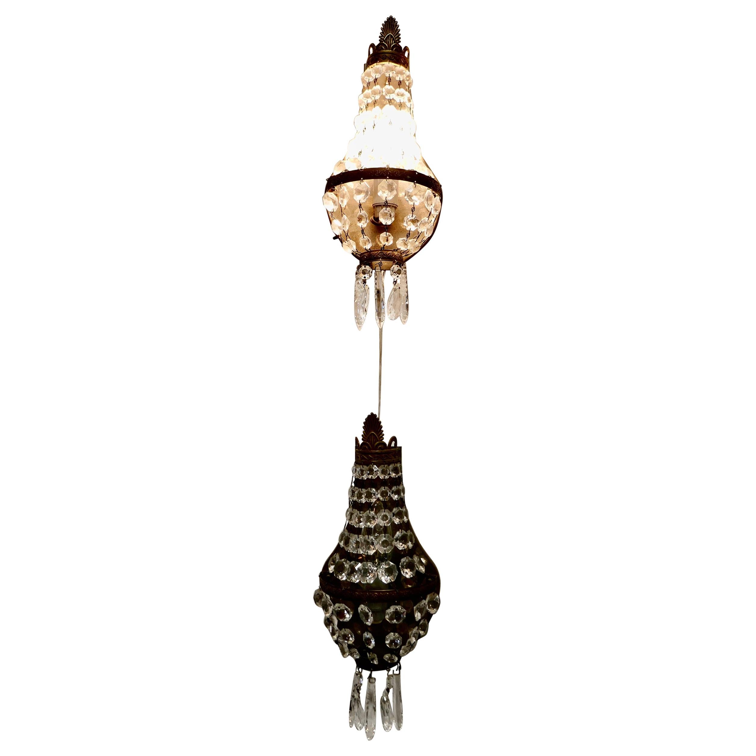 Pair of French brass and crystal chandelier wall lamps,

This is a very a pretty pair, the brass the lamps have chains of lusters draping from the top outwards forming a tent, which encloses the bulb

A rare pair, the lamps look sensational when
