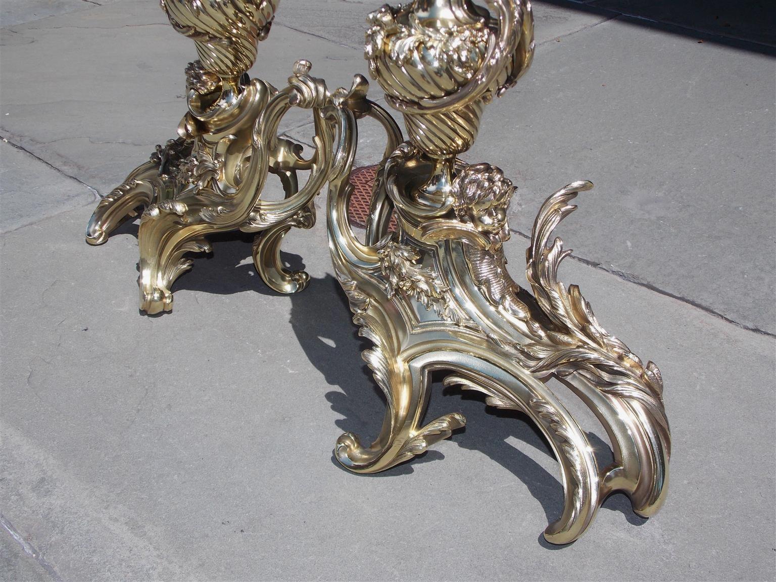 Cast Pair of French Brass Flame Urn Finial and Winged Cherub Floral Chenets, C. 1820 For Sale