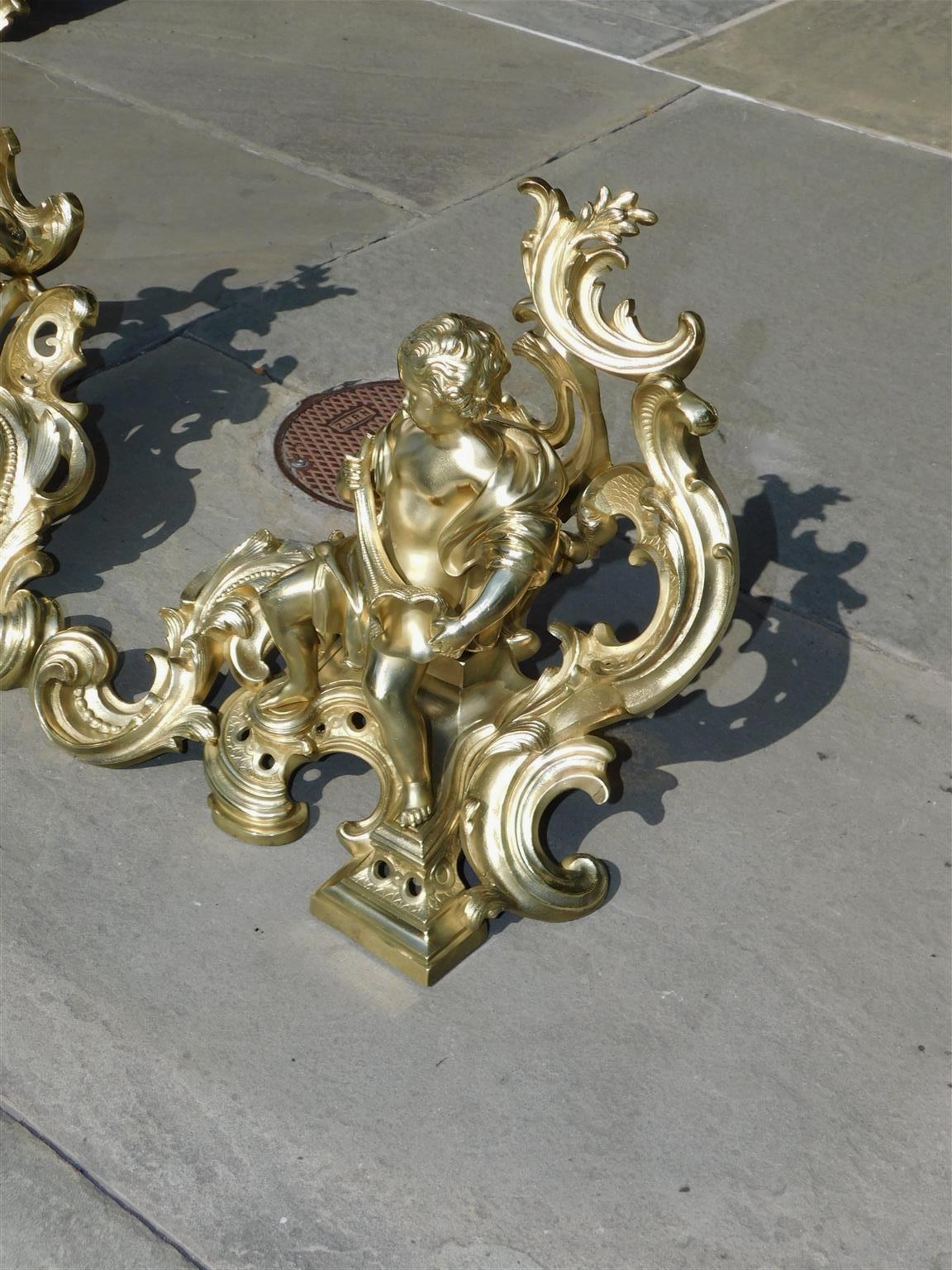 Early 19th Century Pair of French Brass Flanking Figural Musical & Foliage Scrolled Chenets, C 1810 For Sale