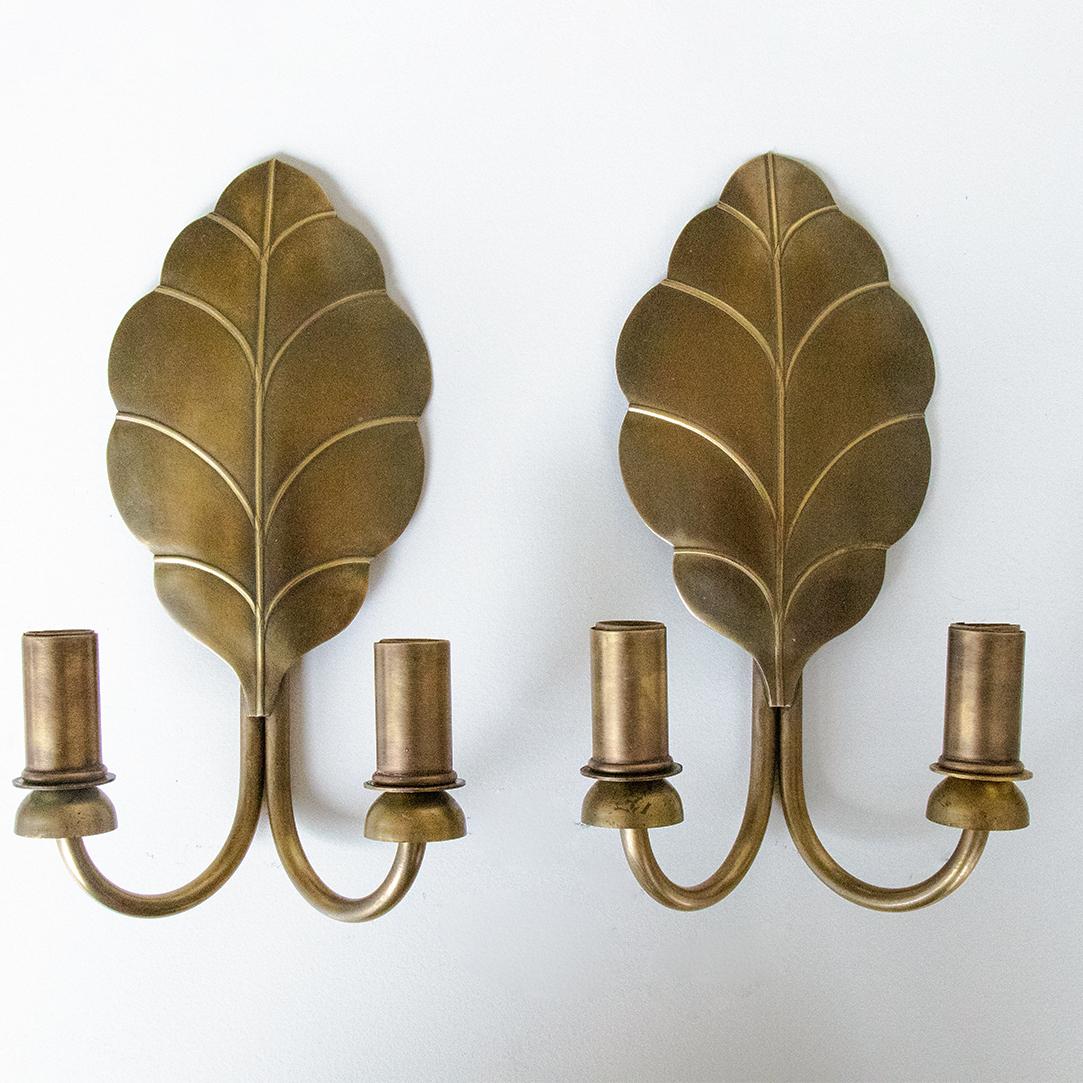 Vintage pair of brass leaf sconces from France. Beautiful large leaf shape with two curved brass arms with sockets. Newly rewired. Excellent condition.