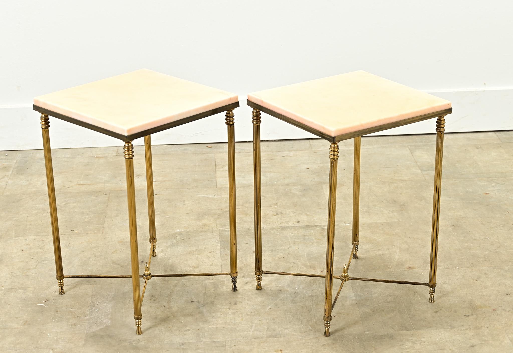 This vintage pair of French brass and faux marble tables are perfect side tables for your interior. The faux marble tops rest over fluted brass bases. Be sure to view the detailed images to see the current condition.