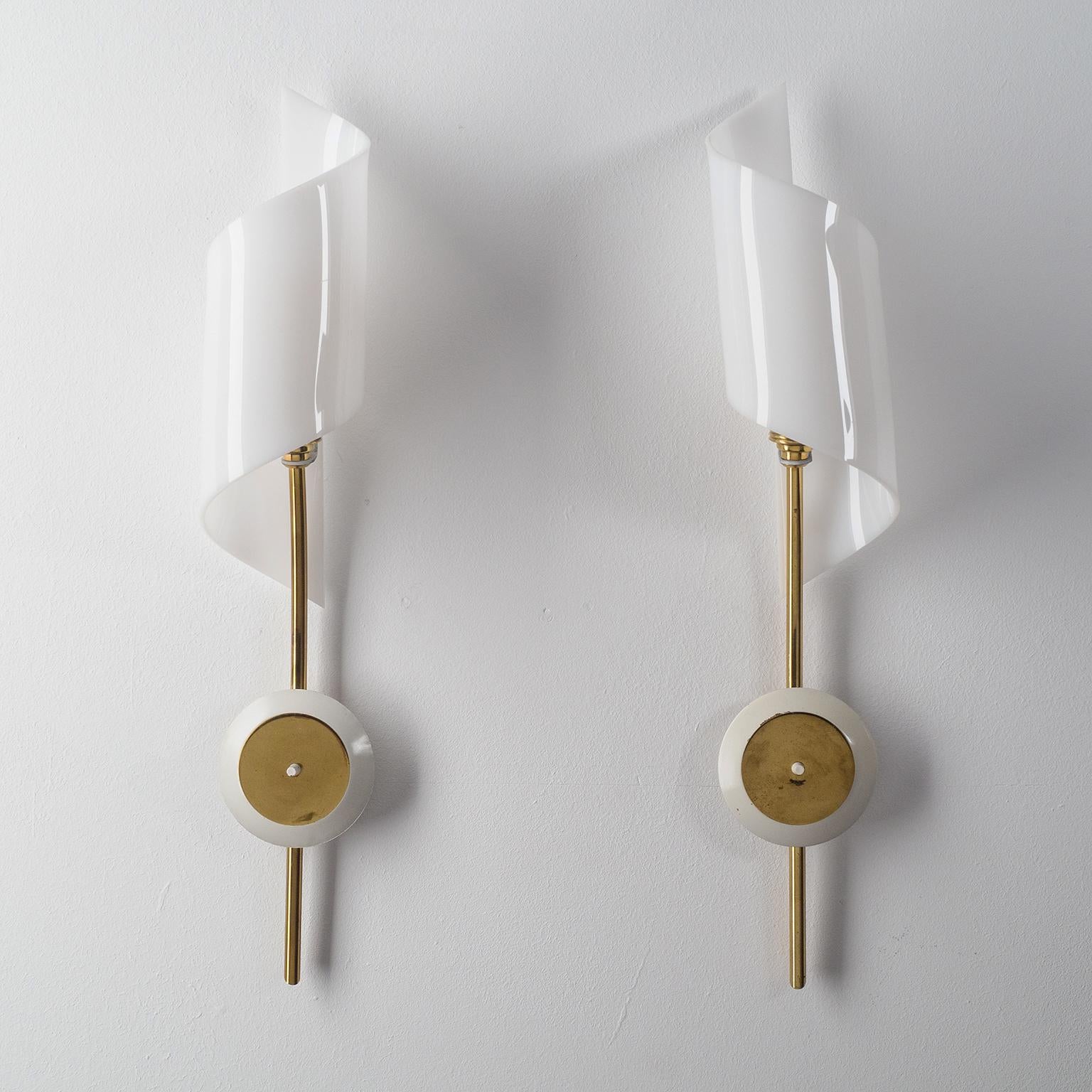 Very fine pair of French modernist sconces, circa 1960, attributed to Arlus. Slender all-brass hardware (partially lacquered) with 'twisted' acrylic shades. Very nice original condition with a light patina on the brass. One brass and ceramic E14