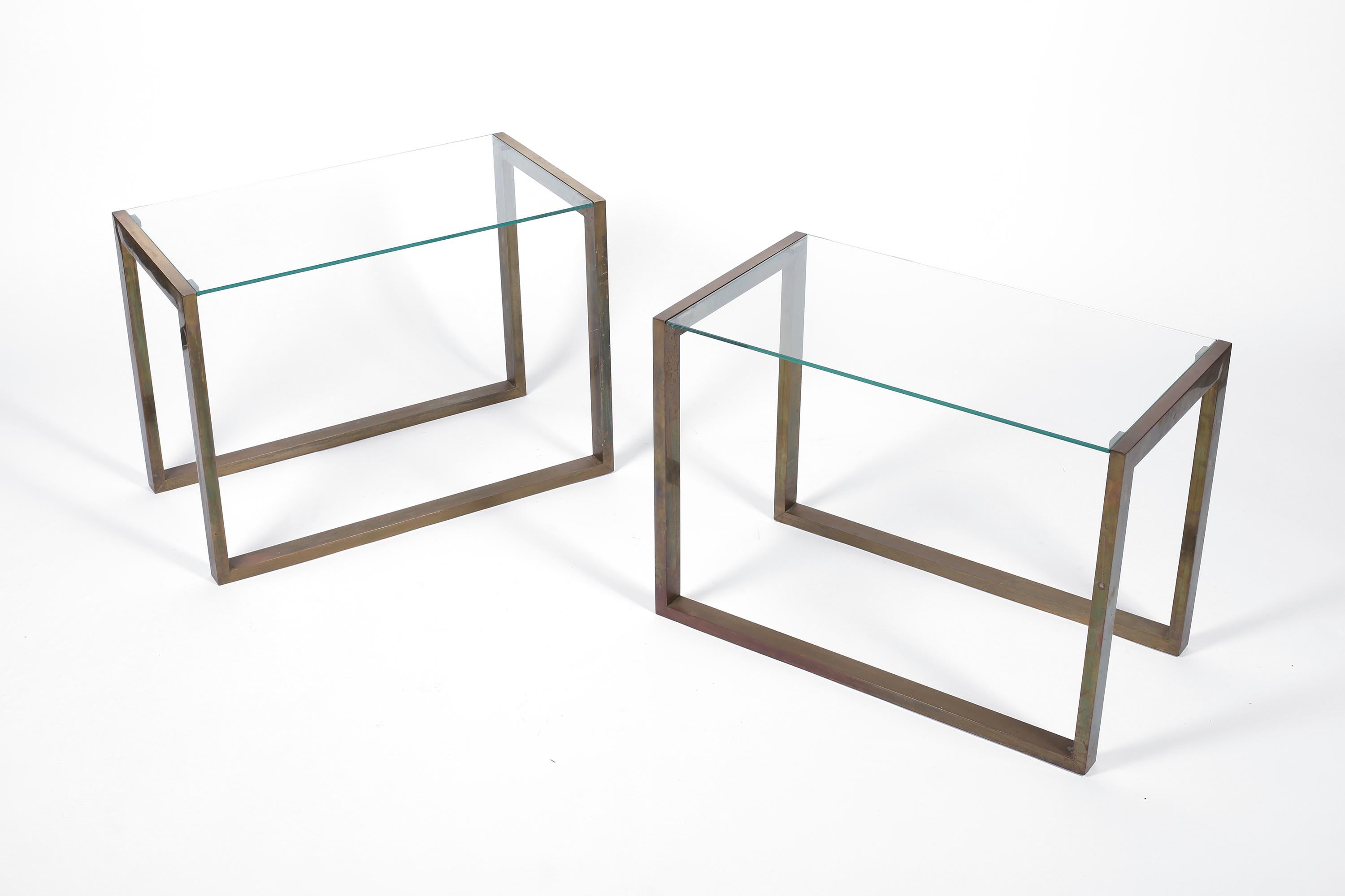 A pair of chic patinated brass side tables with simple angular frames and inset clear glass tops. French, circa 1970s.
