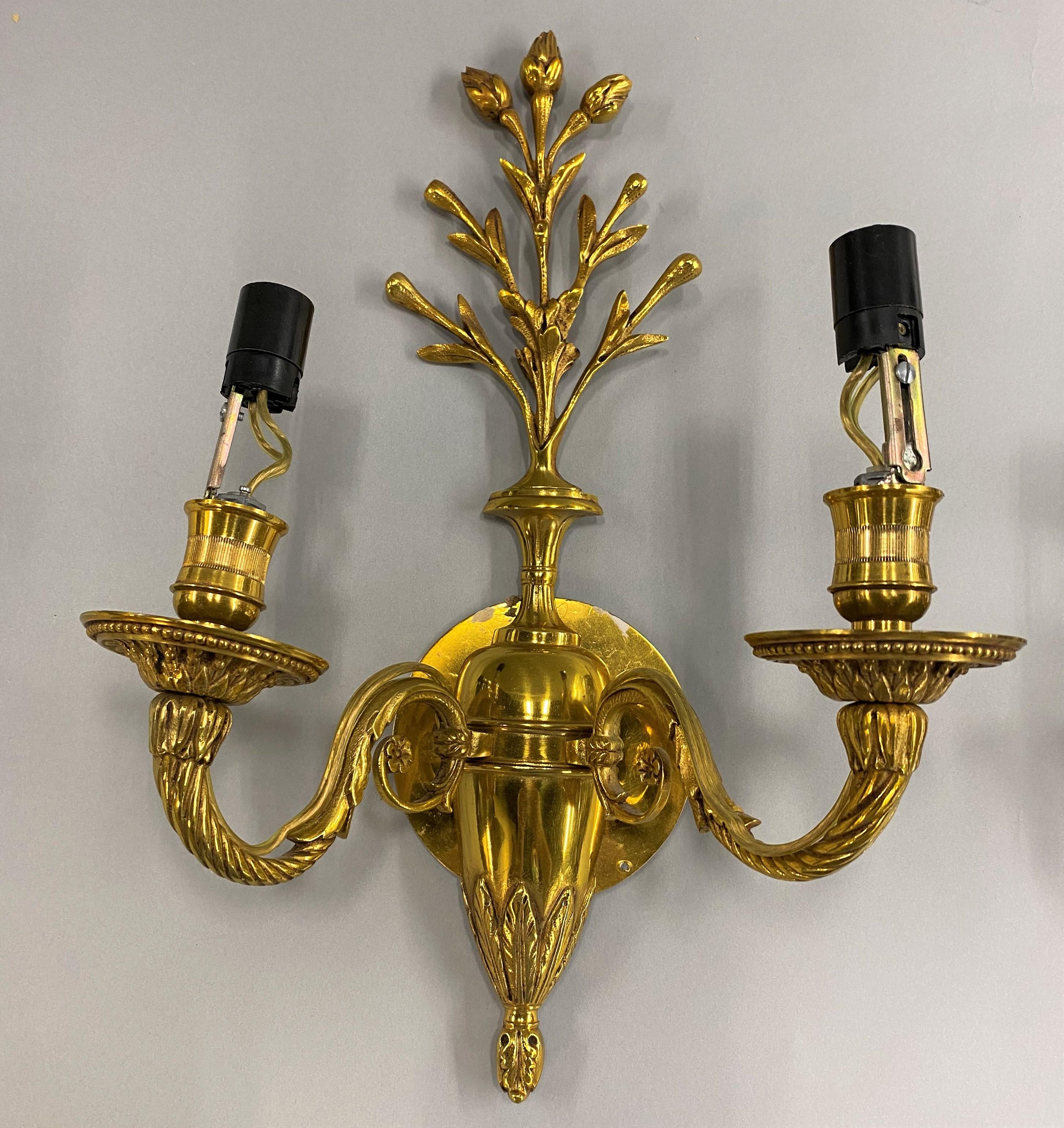 A fine pair of brass two-light sconces with foliate crests and fine detailed scrollwork, unsigned, attributed to Maison Charles. Founded in 1908 by Ernest Charles, Maison Charles is one of the oldest family owned French lighting companies still in