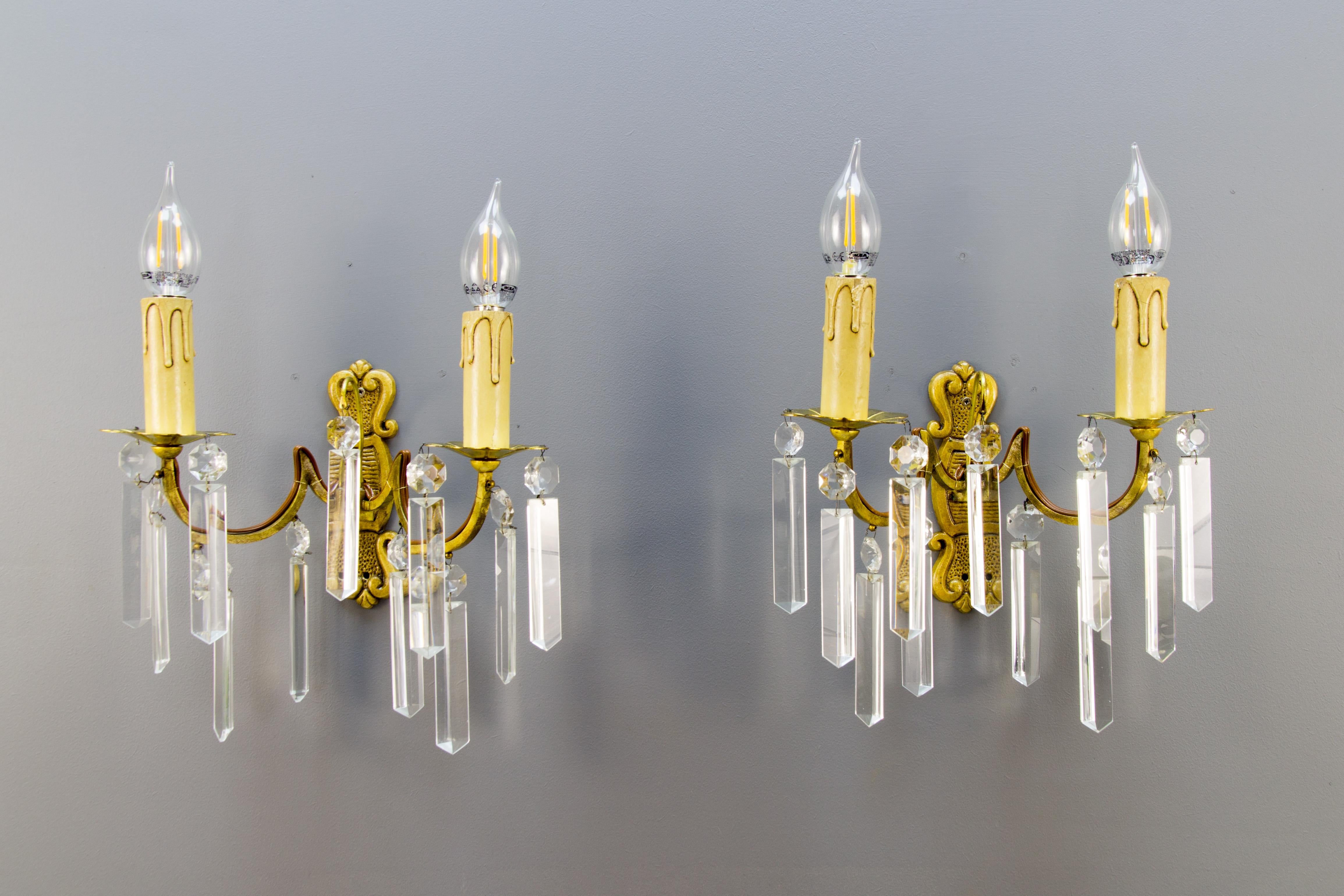 Pair of French bronze and crystal glass twin arm wall sconces, ca. 1930
A beautiful pair of bronze ornate wall sconces hung with crystal prisms. Each sconce has two arms, each with one socket for the E14 size light bulb, France, the first half of
