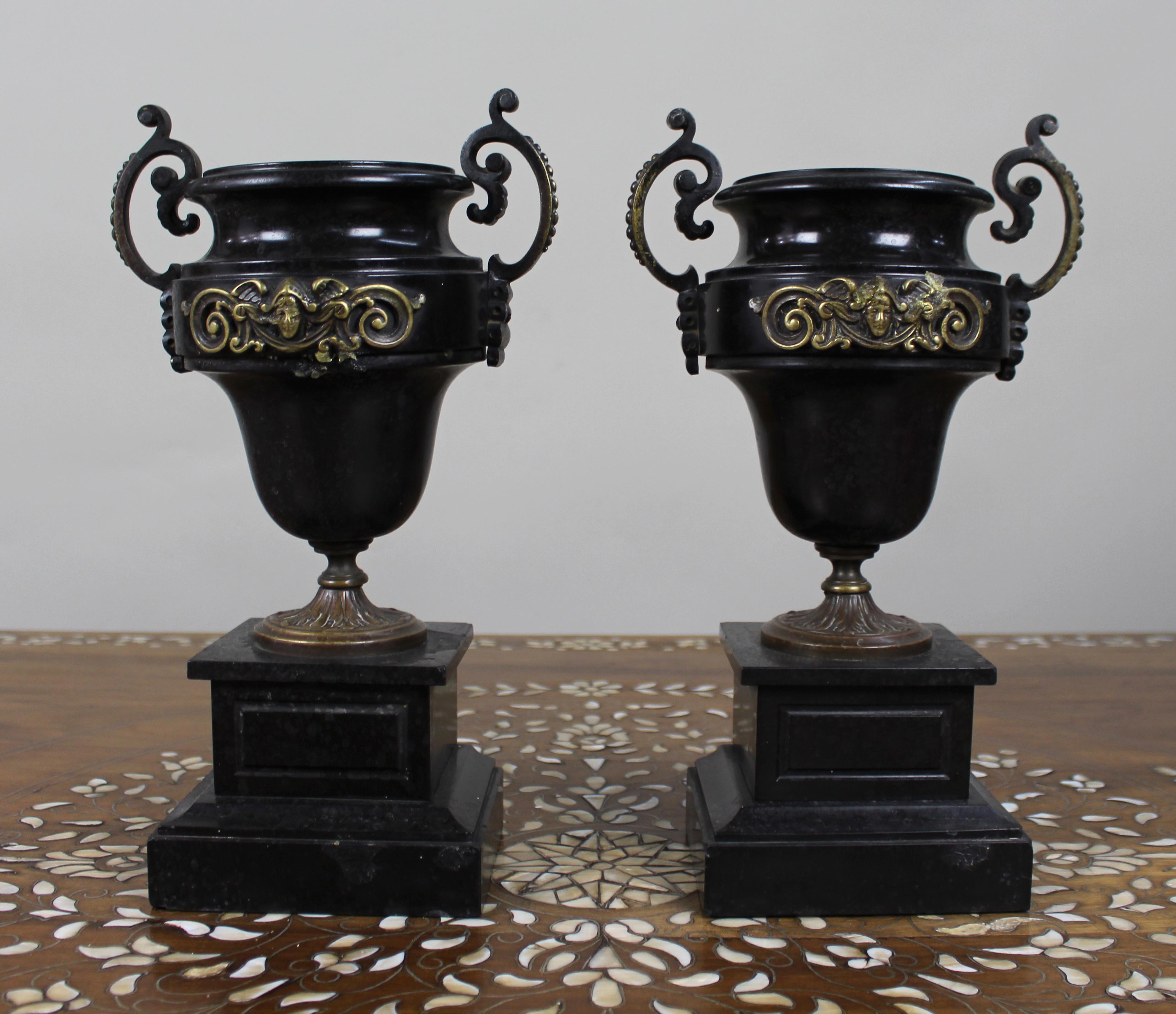 Pair of French Bronze and Marble Urns

France, circa 1870

A decorative pair of 19th-century French urns in the neoclassical style, finely cast and mounted in gilt and patinated bronze on black marble plinths. Each urn of campana form with twin