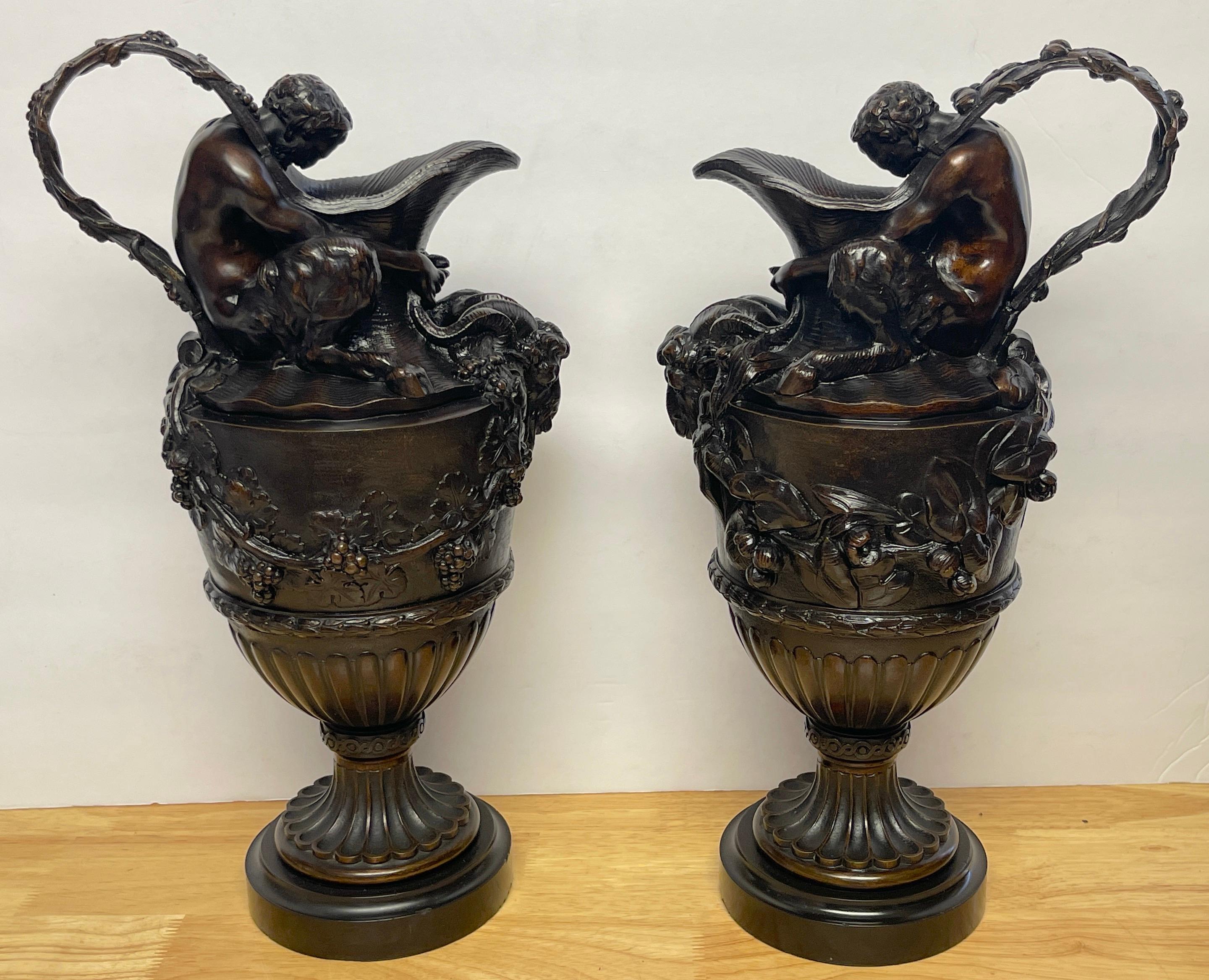 Pair of French Bronze Figural Ewers in the Manner of Claude Michael Clodion
France, circa 1890-1900, Unsigned. 
An exceptional pair of finely cast figural ewers, each one with naturalistic grape encrusted twin strap handles, with a seated satyr on