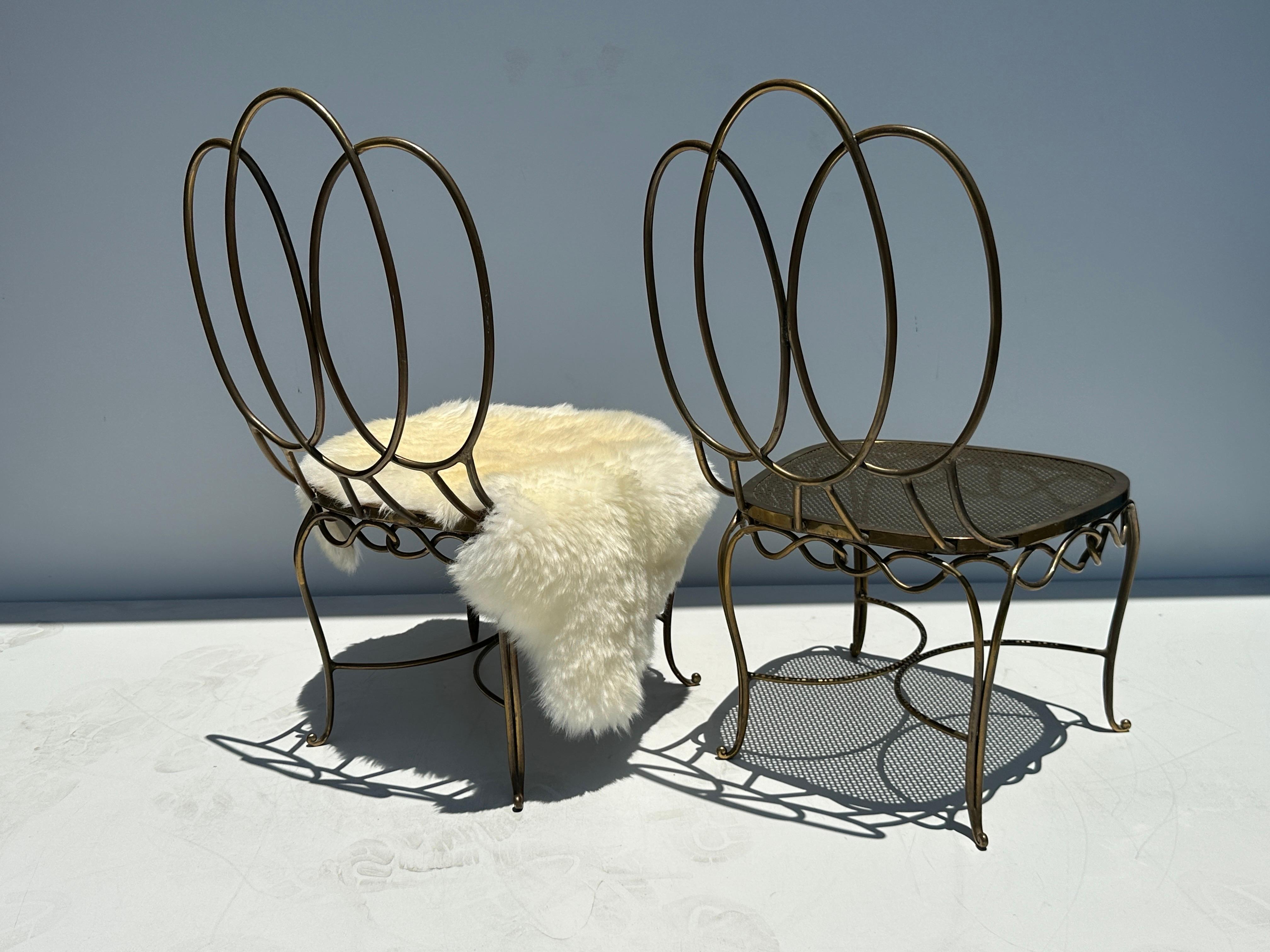 Pair of patinated bronze / brass low parlour chairs in the style of Jean Royere. Sheep fur shown is decorative and not included.